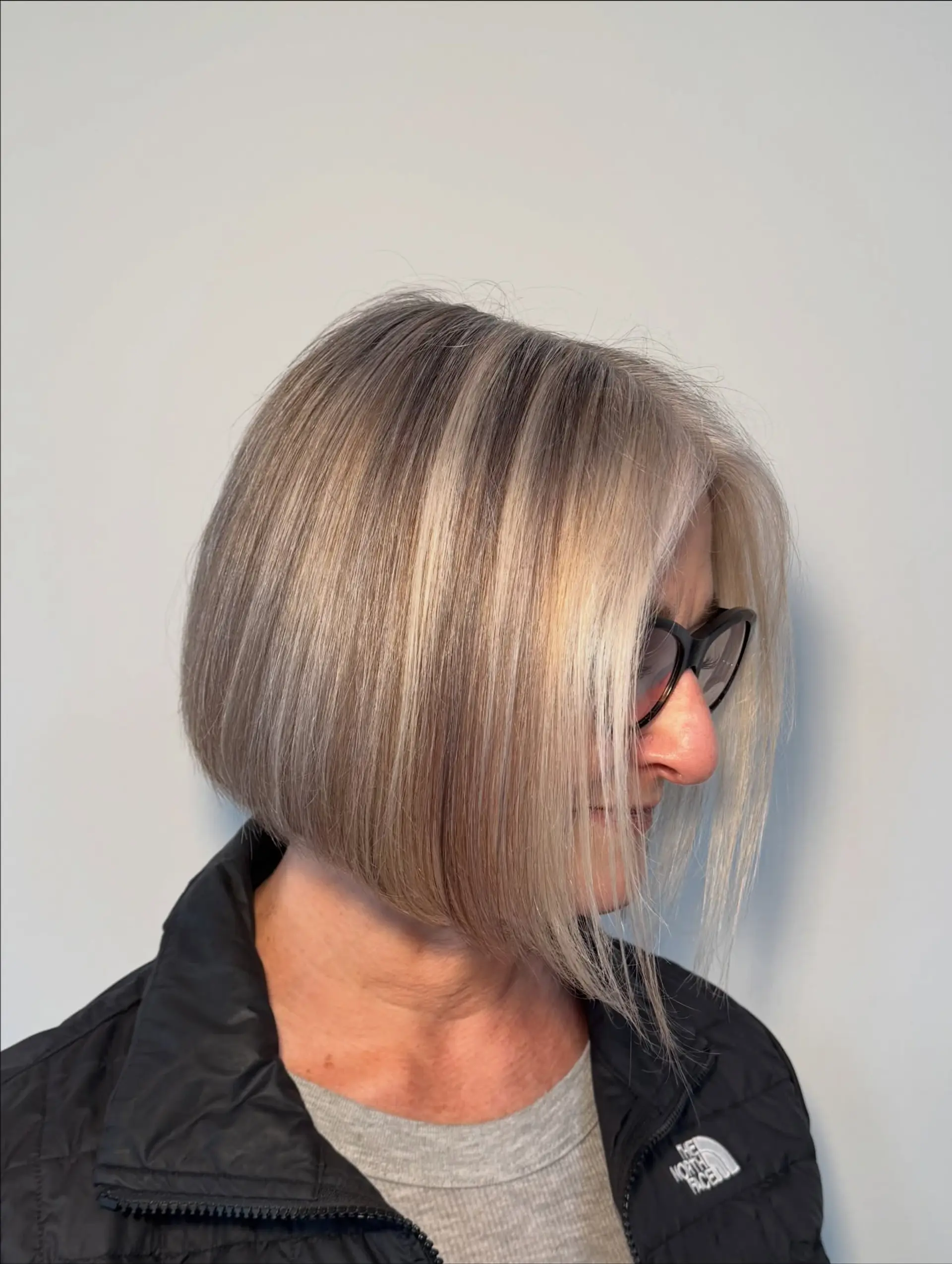A sleek, precision-cut angled bob with fine blonde highlights. 1