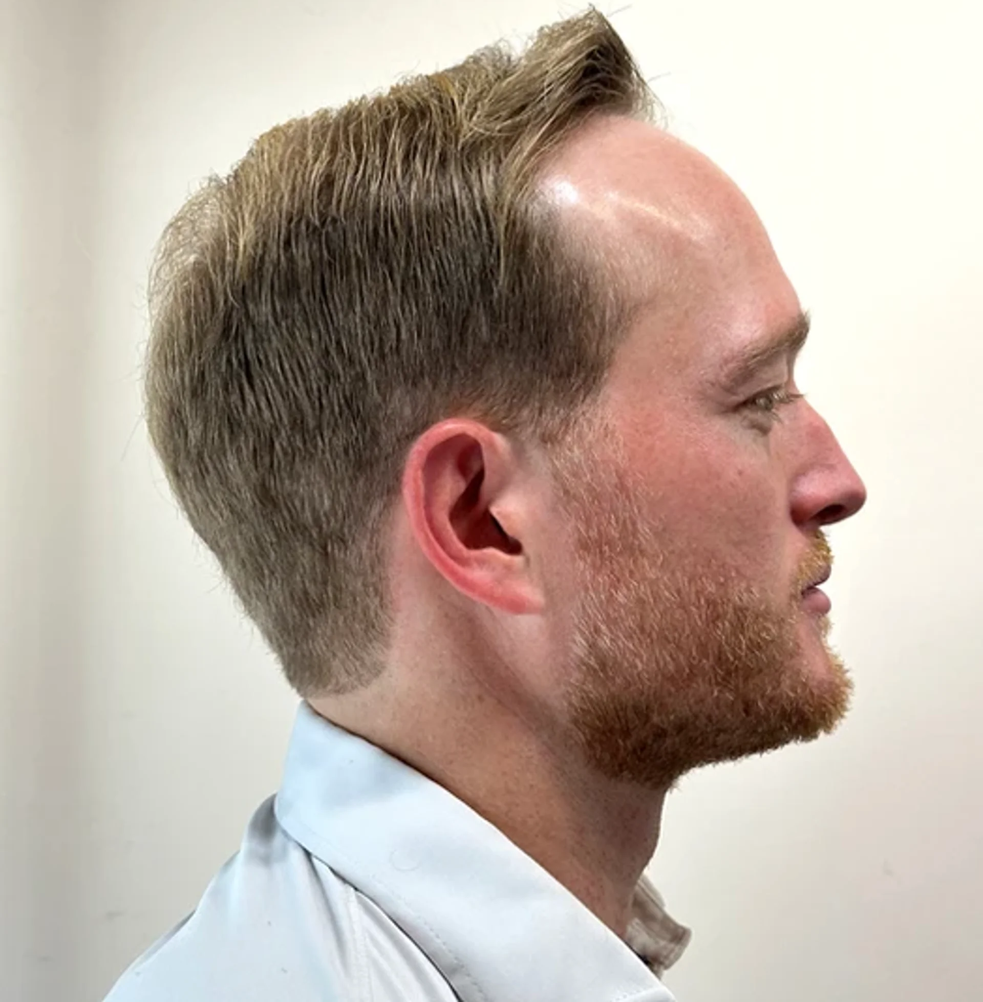 Stylish men's haircut with a sleek fade and modern silver highlights, showcasing a contemporary grooming trend. - Preview 3