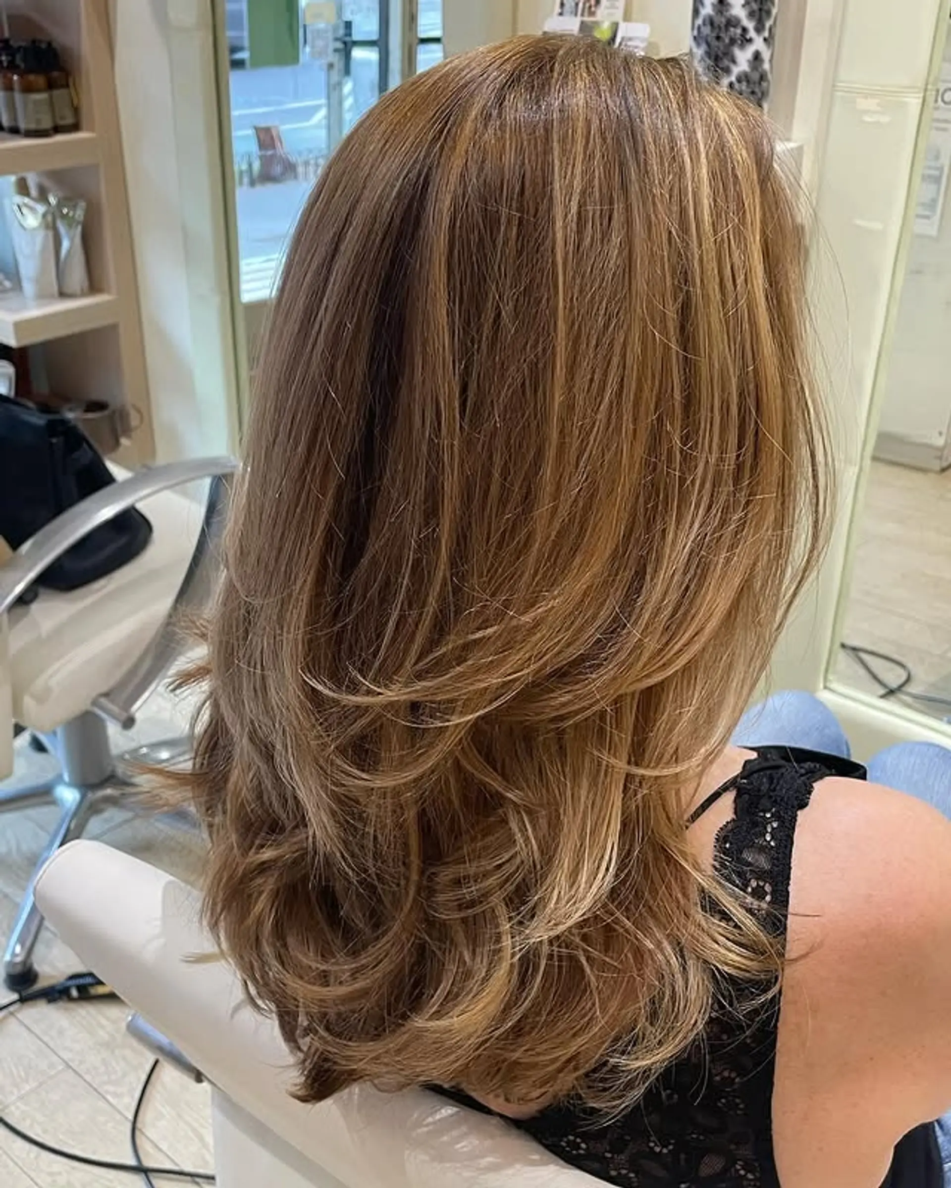 A medium-length, layered hairstyle with face-framing layers. The layers add movement and volume. 1