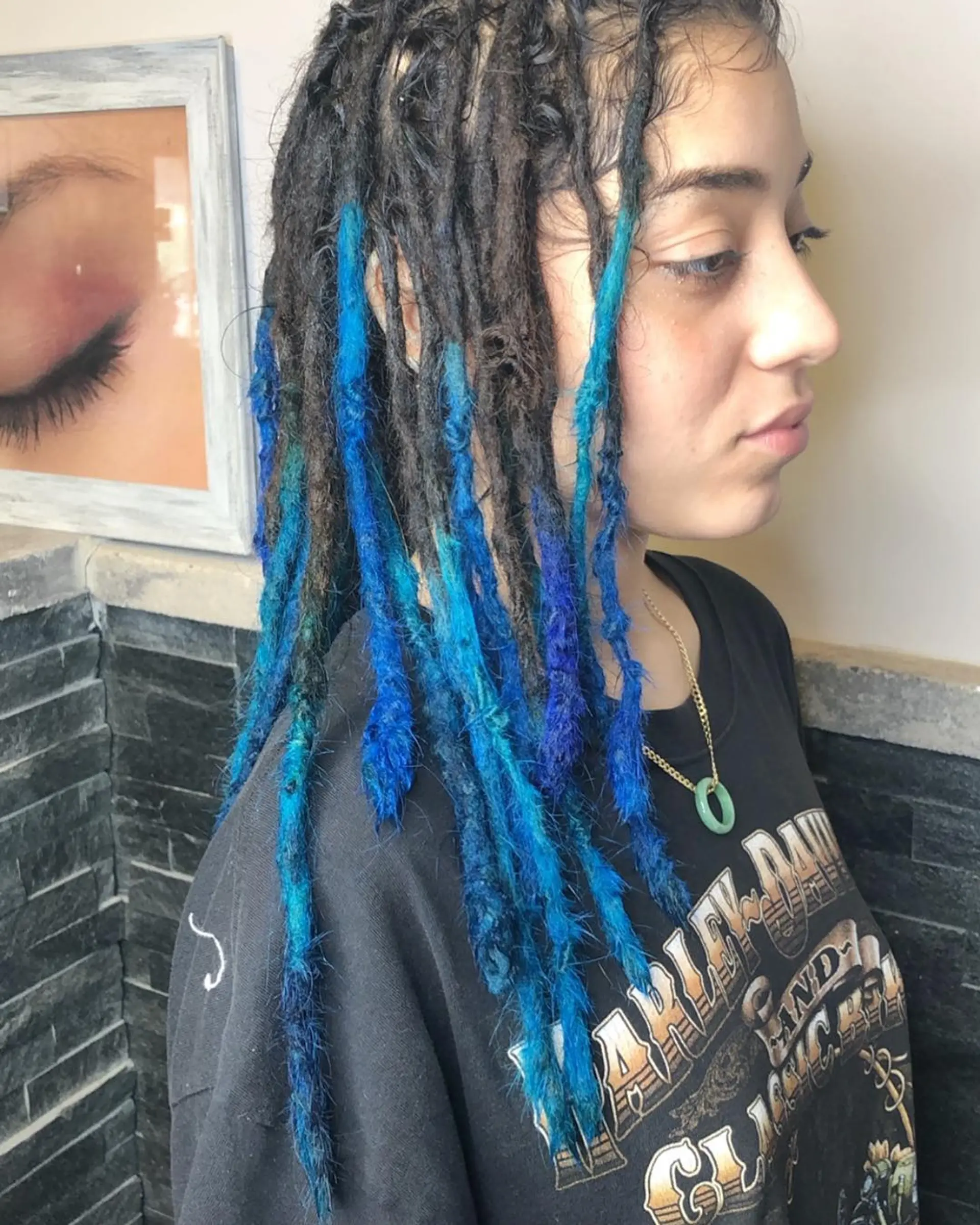 Long, coiled dreadlocks with vibrant blue and bright blue tipped ends, creating an edgy and unique two-tone look. 1