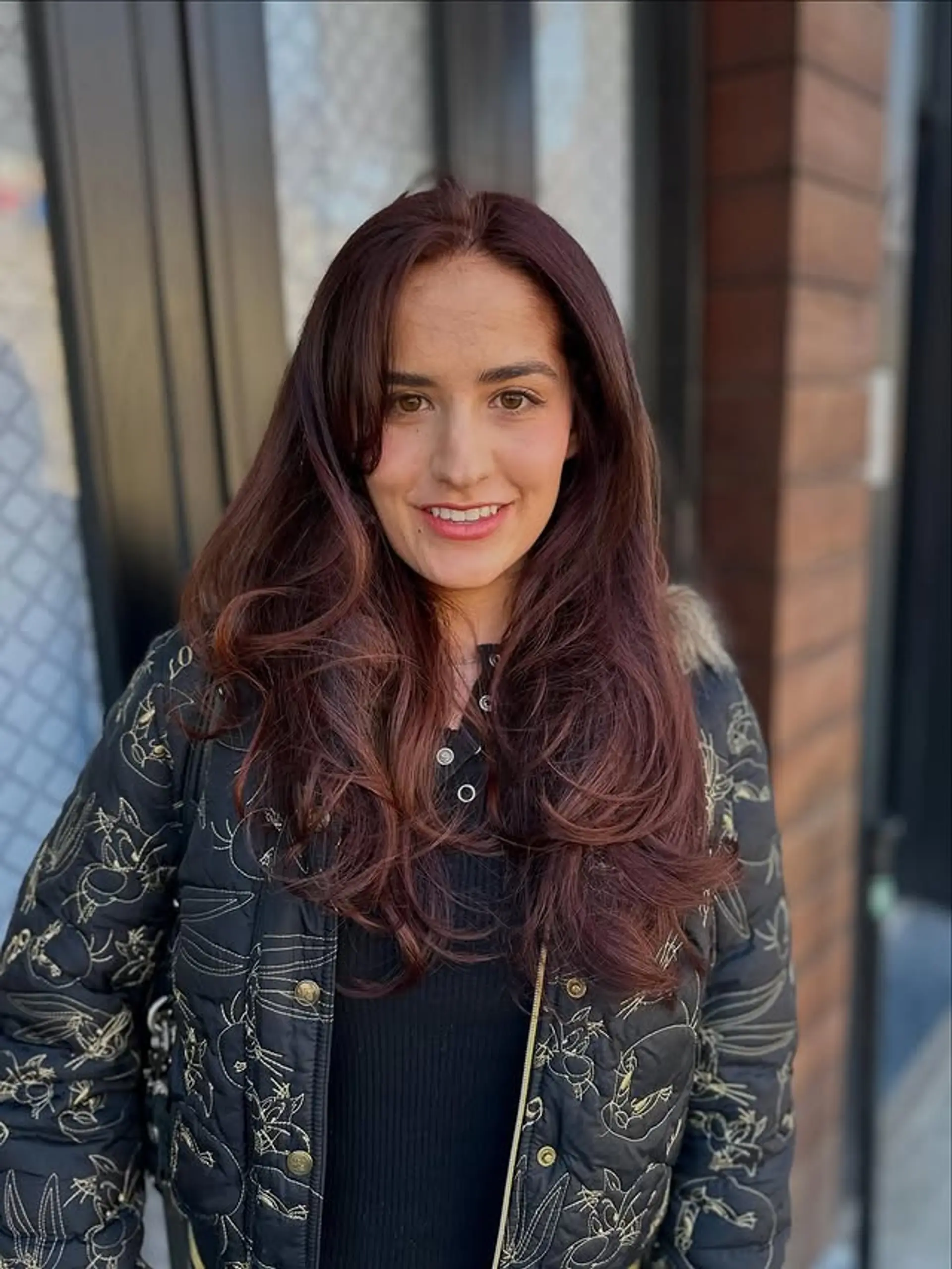 A layered, wavy hairstyle with subtle side bangs that frame the face. 1