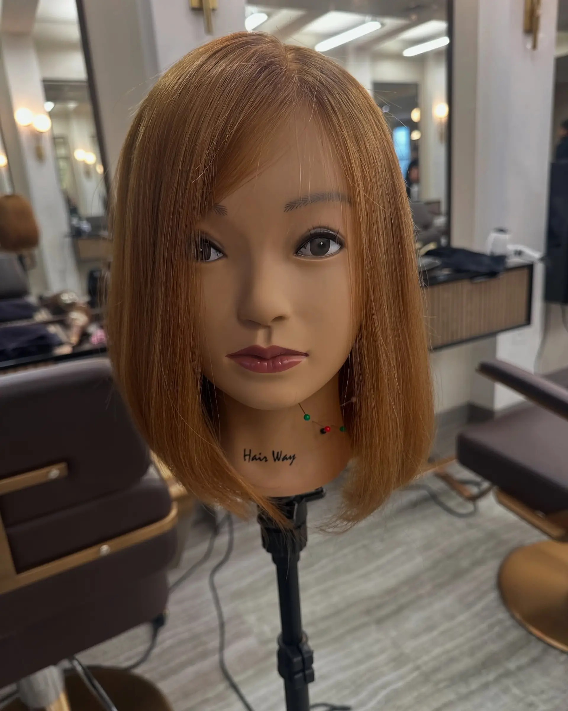 A sleek, shoulder-grazing straight bob in a vibrant copper tone with side-swept bangs. 1