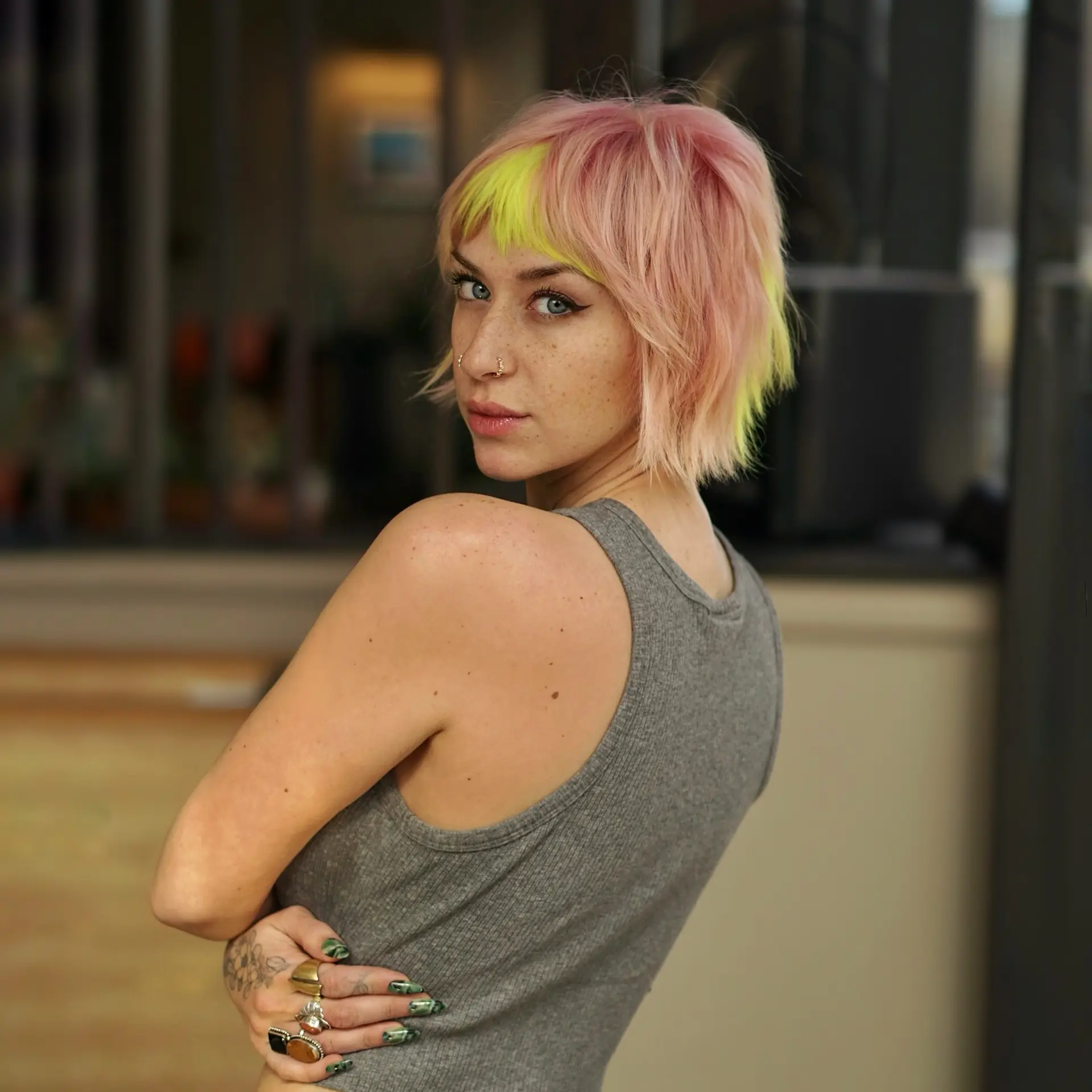 A textured short bixie cut featuring soft pastel pink tones contrasted with vibrant neon lime-yellow fringe accents. 1