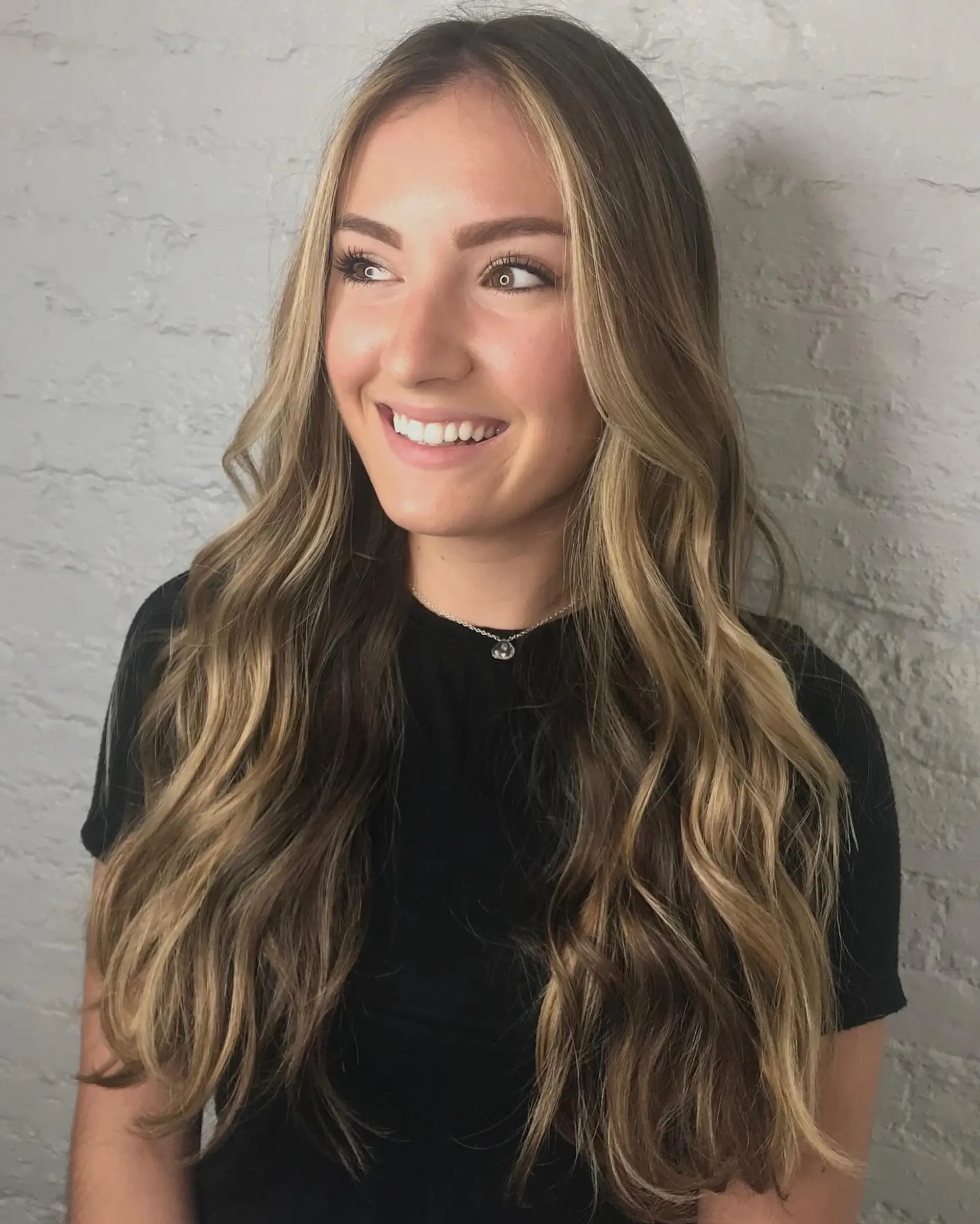 Long dimensional blonde hair styled in soft, cascading waves with bright face-framing highlights. 1