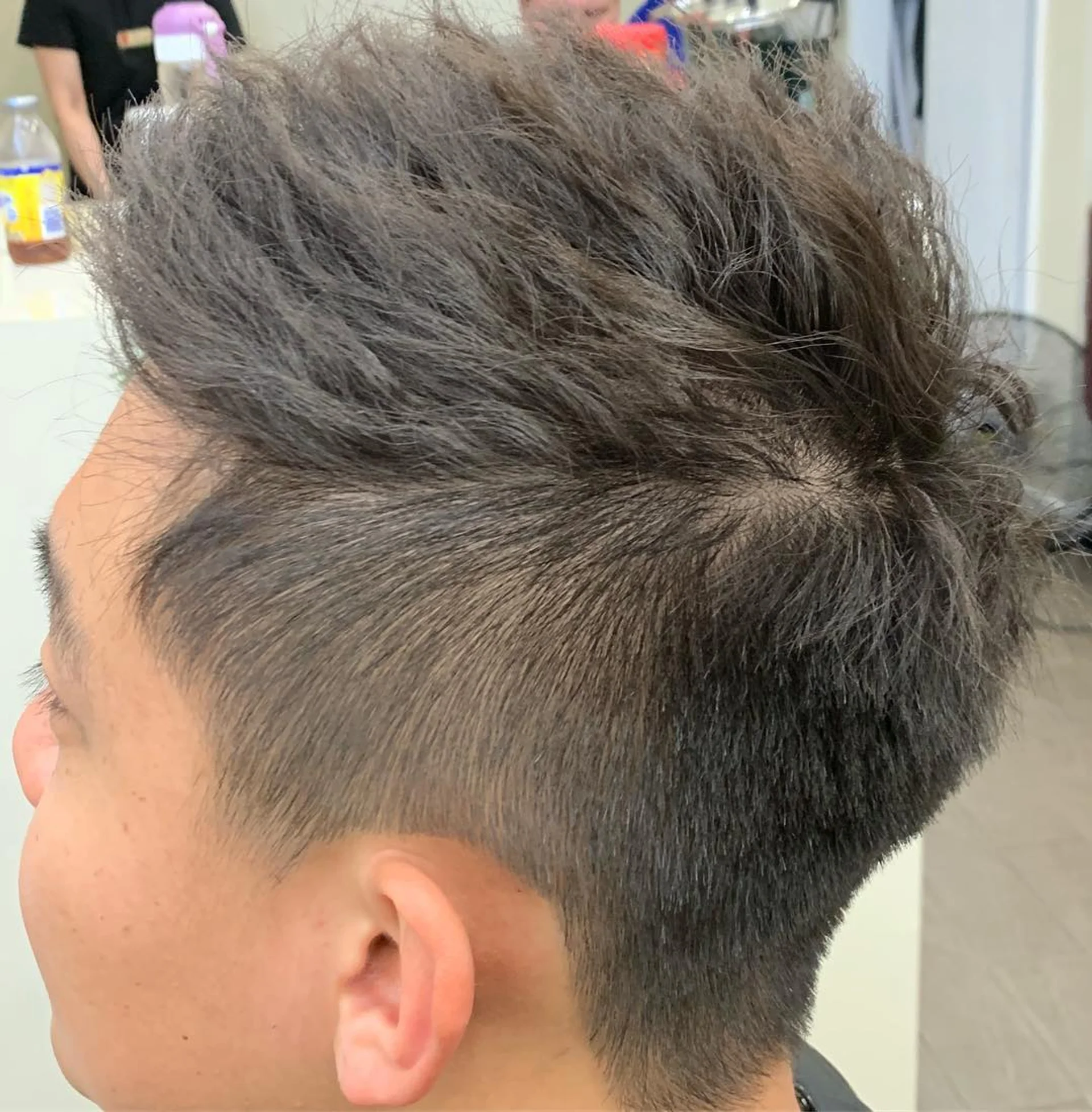 A two-block hairstyle with an ash blonde top and dark, short undercut sides, seen from the side. - Preview 3