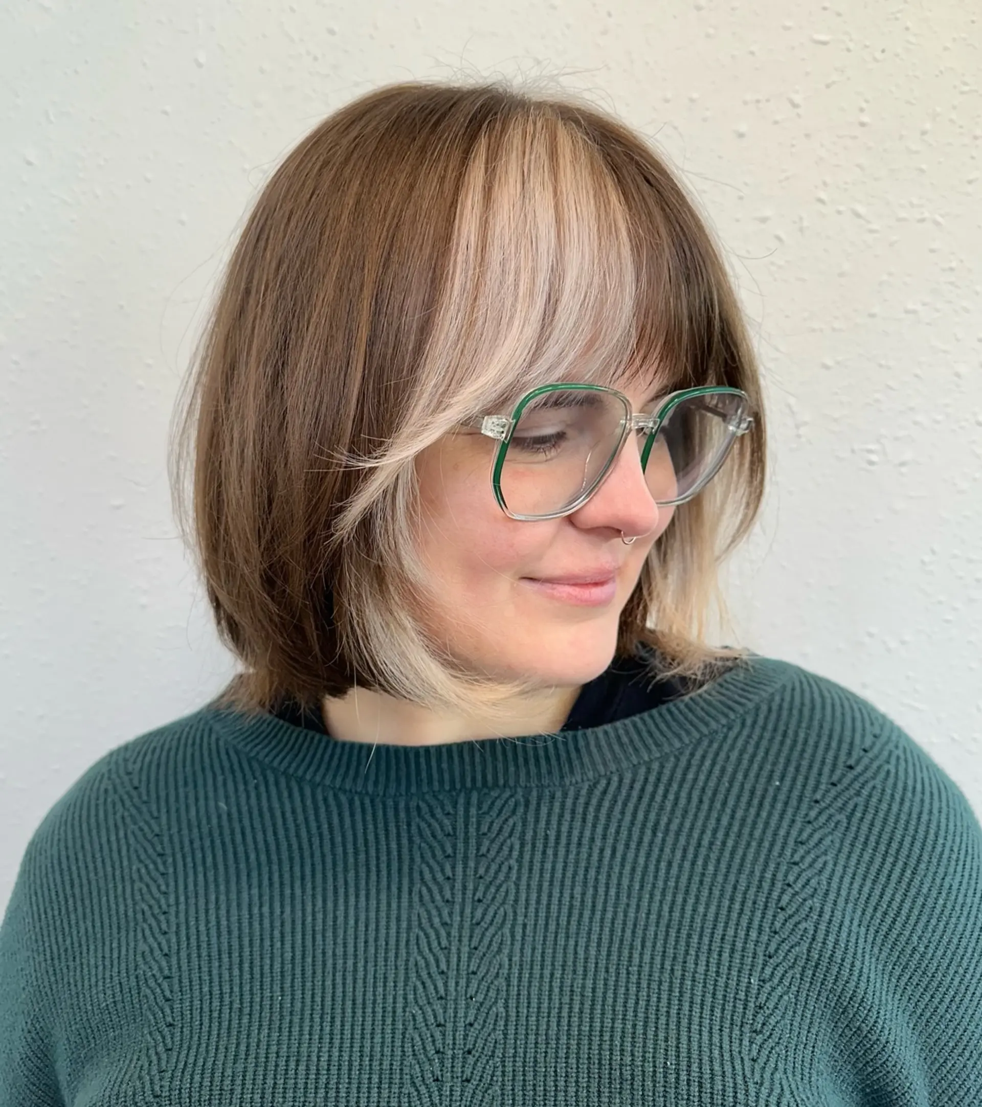 A textured Italian bob with an eye-skimming fringe and face-framing pieces highlighted in a contrasting blonde color block. 1