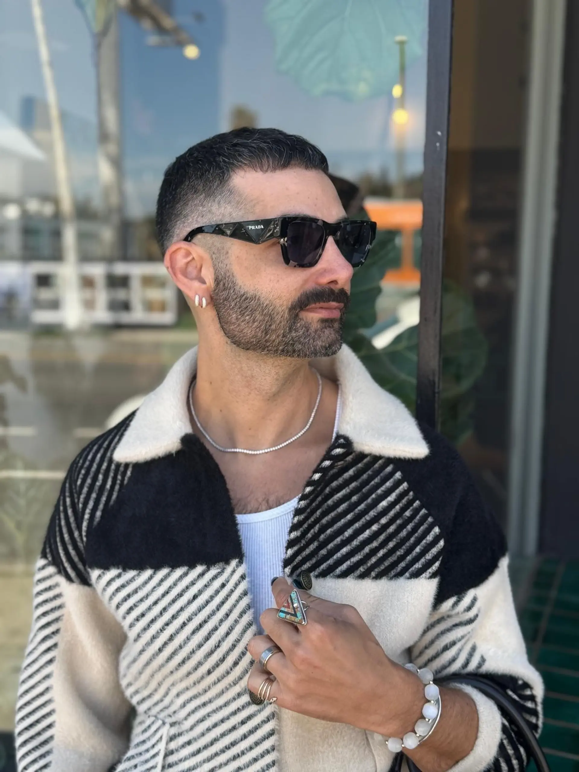 A sharp, modern short crop haircut featuring a textured top and clean faded sides seamlessly blended into a groomed beard. 1