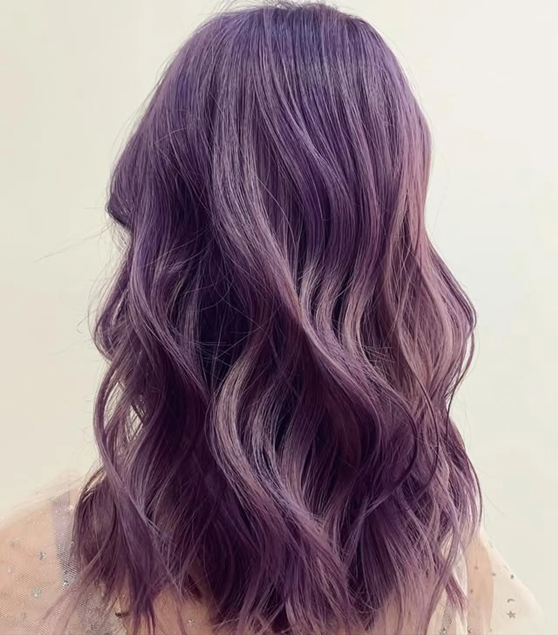 Wavy, shoulder-length style with a vibrant lilac color. 1