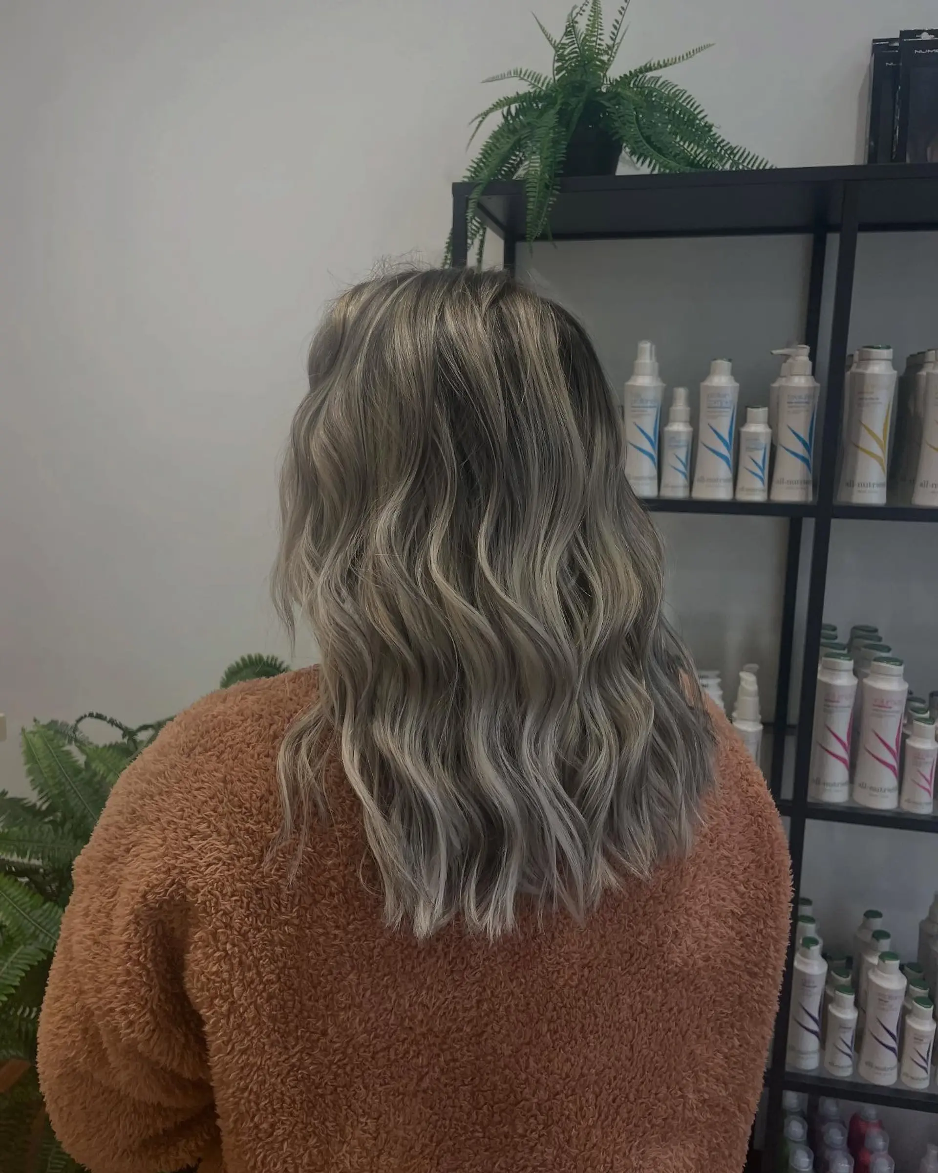 Medium-length wavy hair featuring cool ash blonde highlights seamlessly blended over a natural base. 1