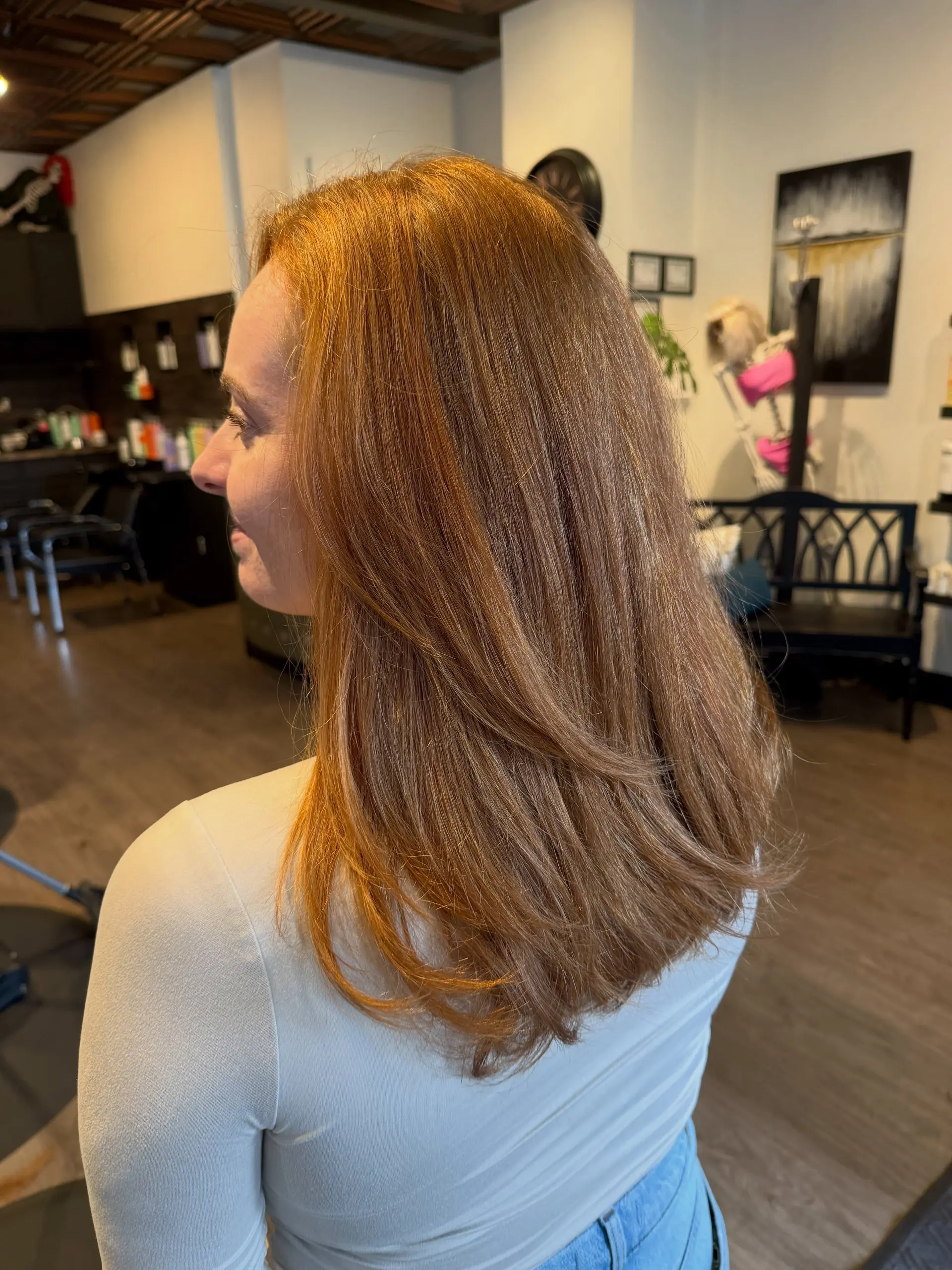 Medium-length dimensional copper hair styled with soft, feathery layers and a smooth blowout. 1