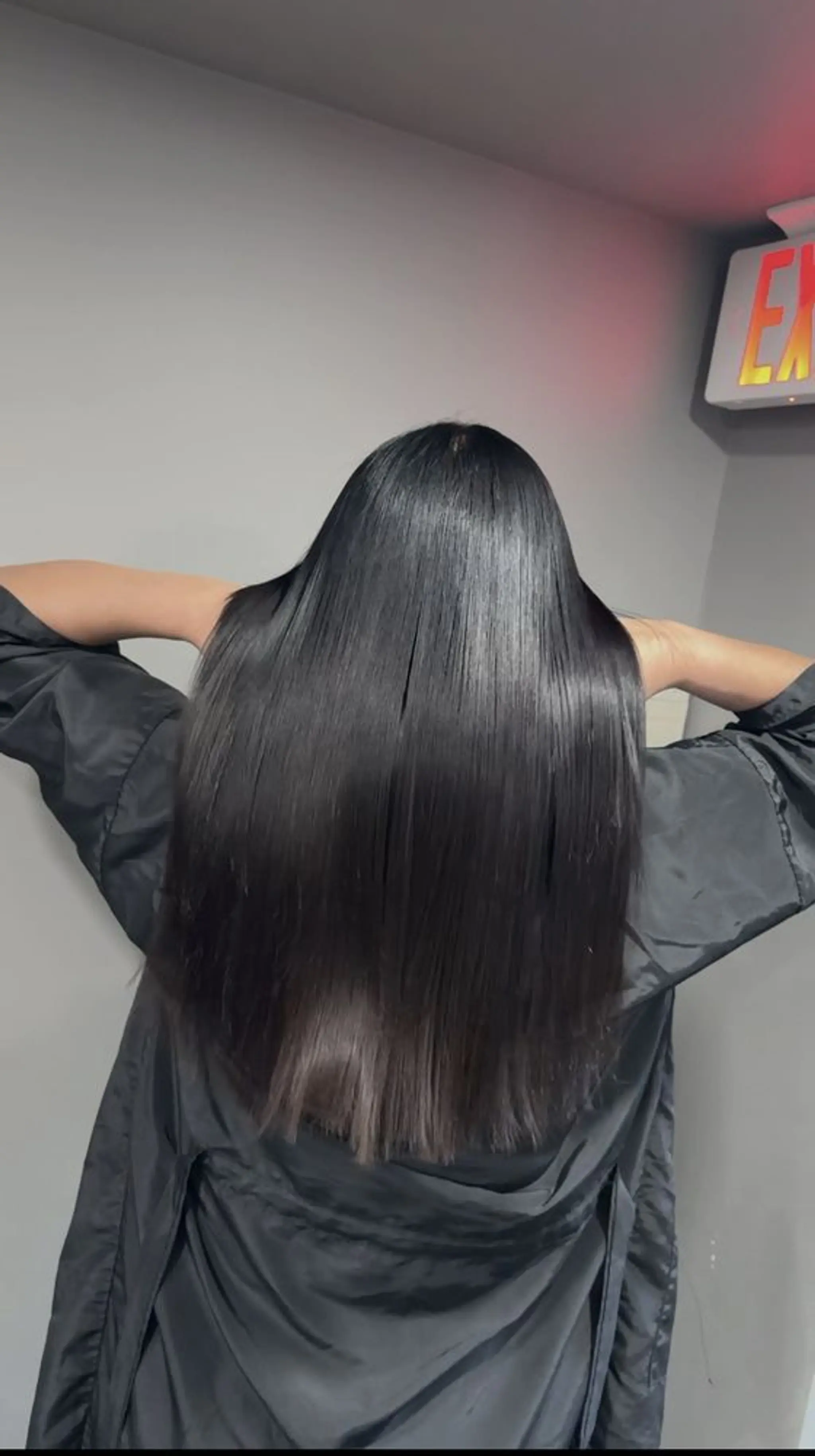 Long, sleek, and straight black hair that is exceptionally shiny and smooth, falling past the shoulders in an elegant, polished style. Come try our keratin treatment!