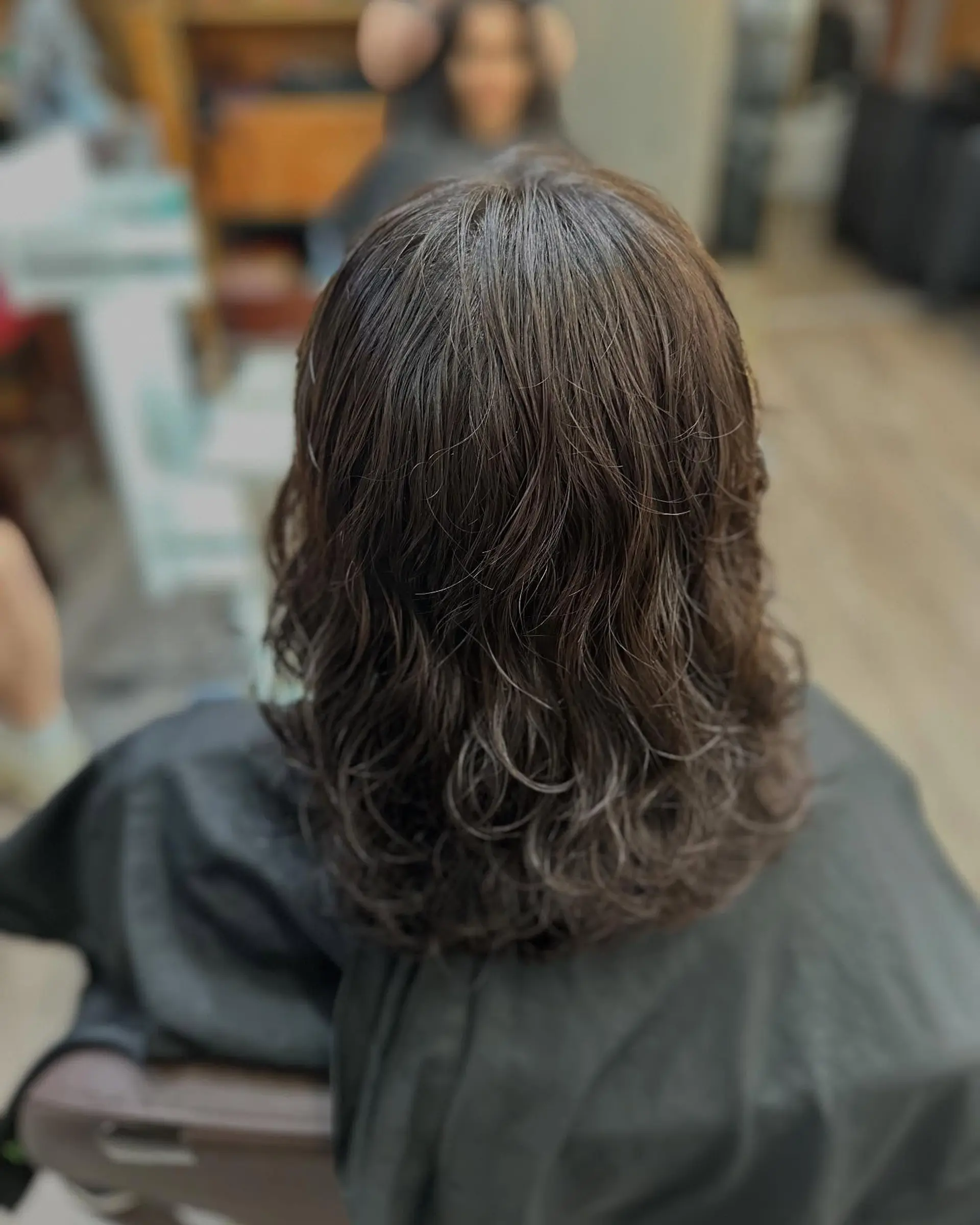 Medium-length dark brown hair featuring soft, textured waves and natural definition from mid-lengths to ends. 1