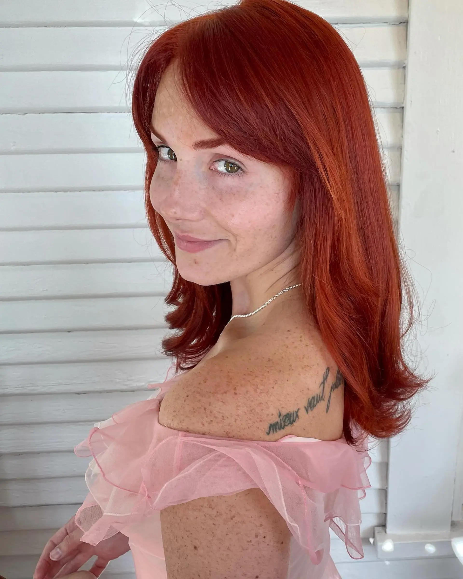 Medium-length vibrant copper-red hair styled straight with softly flipped ends and side-swept bangs. 1