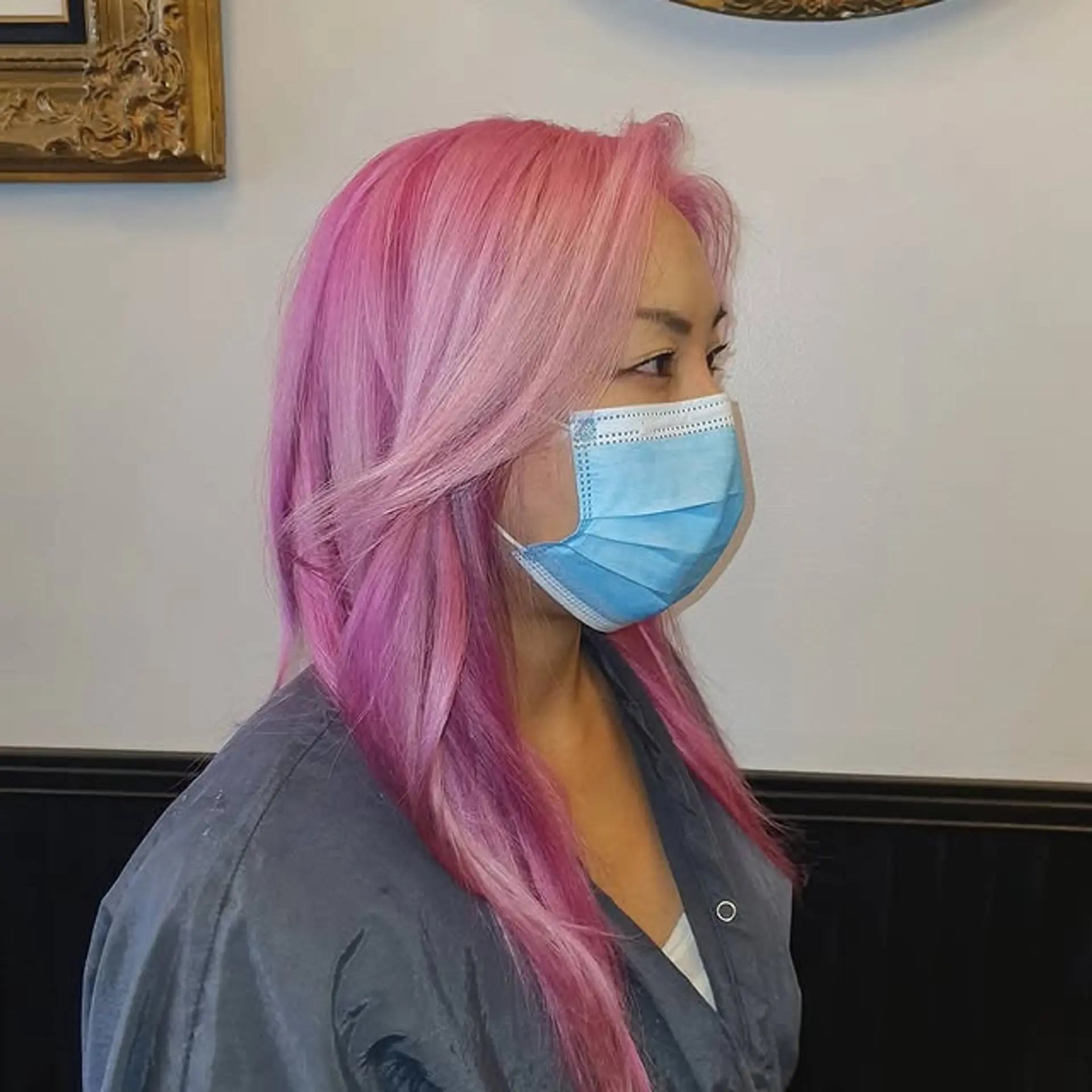 A stunning long, layered hairstyle featuring a bold pink color melt, transitioning from lighter pastel pinks at the roots to richer fuchsia and magenta tones towards the ends. The hair is styled with soft waves and face-framing layers, creating dynamic movement. 1