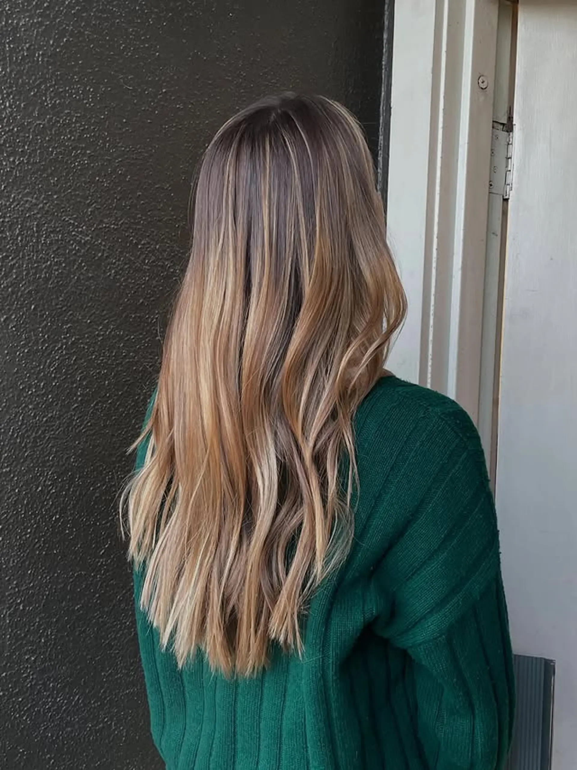 Long layered hair with a honey blonde balayage. 1