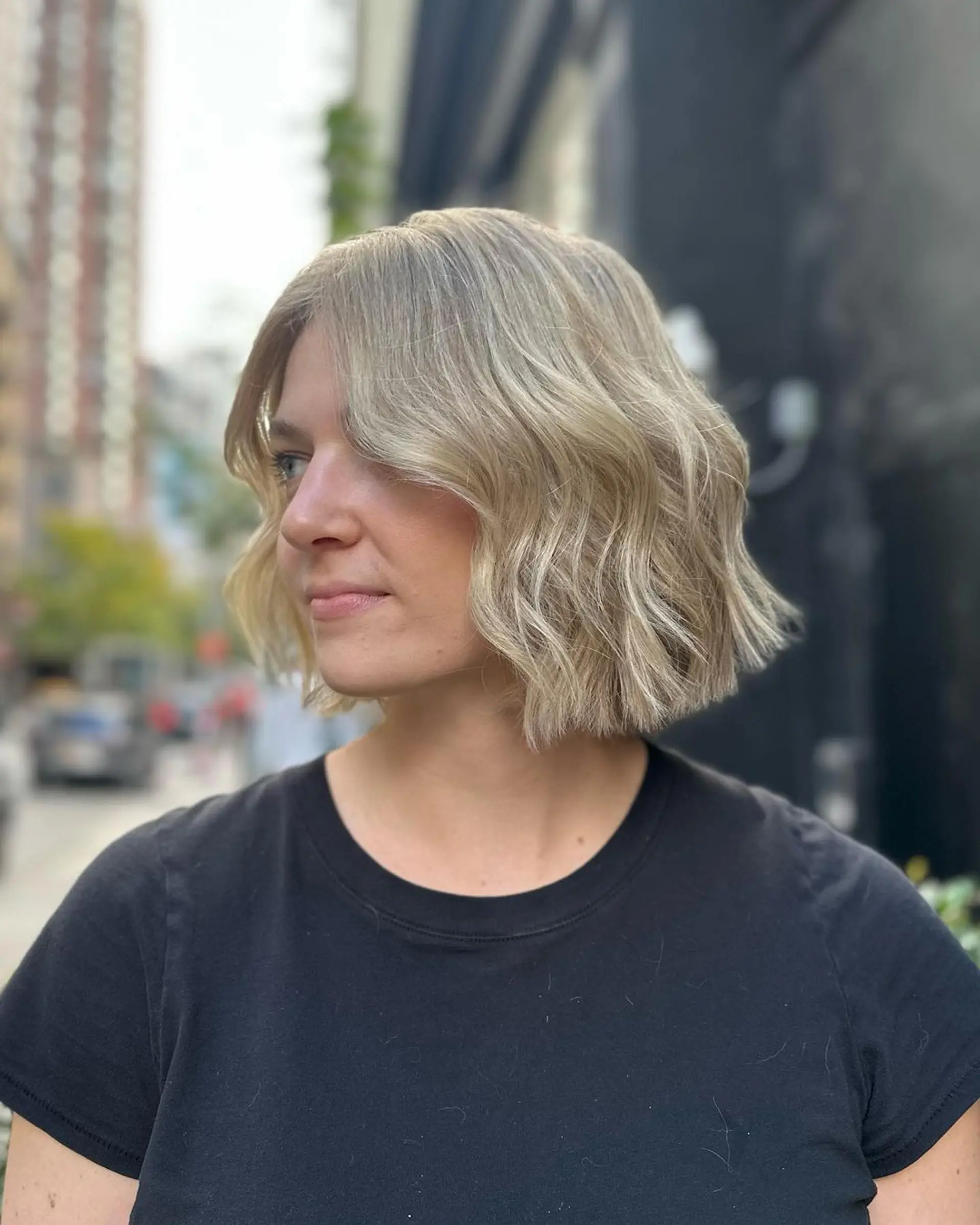 A short, wavy bob cut with platinum blonde and ash blonde hues, featuring a center part and textured ends for a soft, voluminous look.

Color by @simabeautynyc
Cut and style by @juliamannino_hair 2