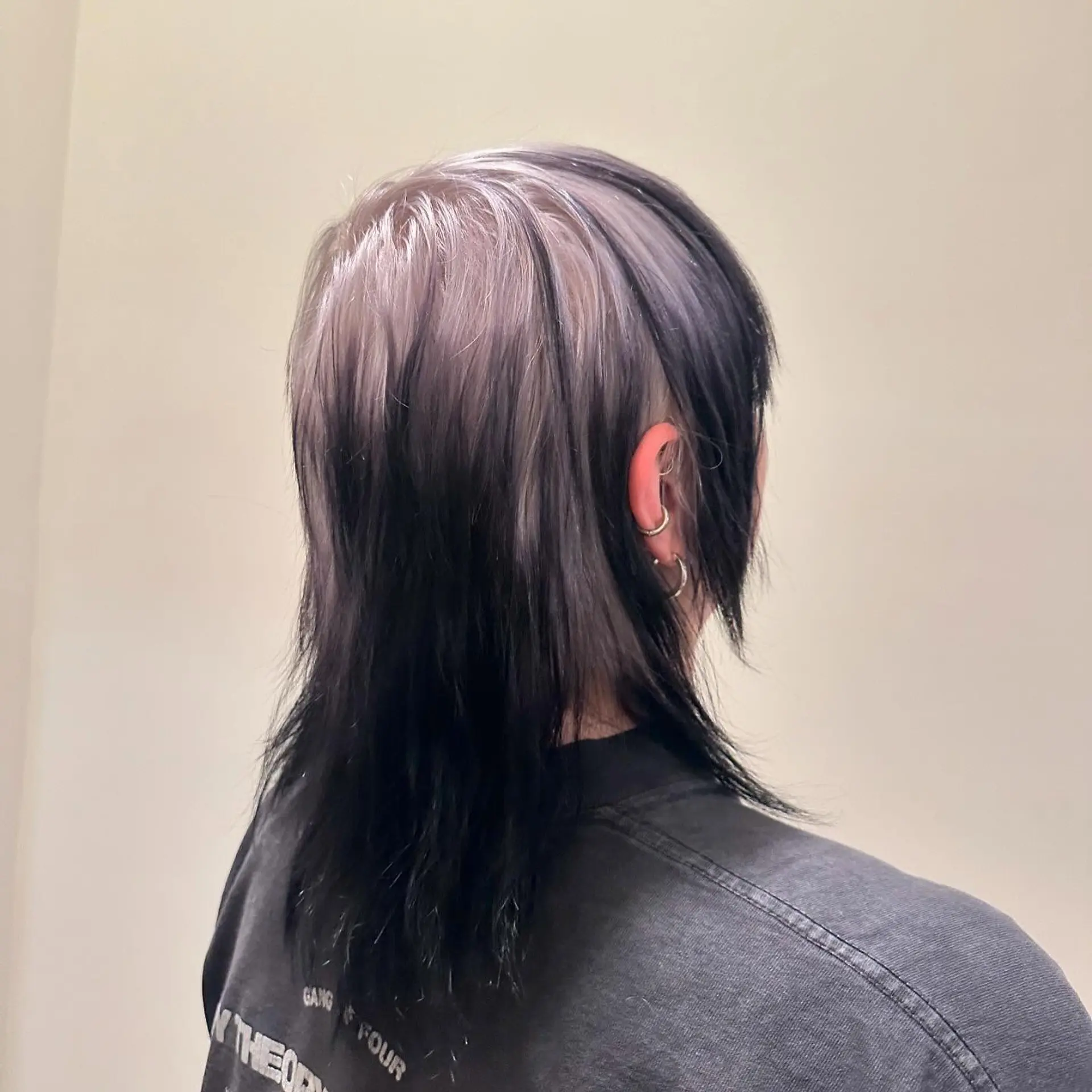 This trendy, medium-length hairstyle features a modern mullet cut with a bold two-tone color contrast. 1