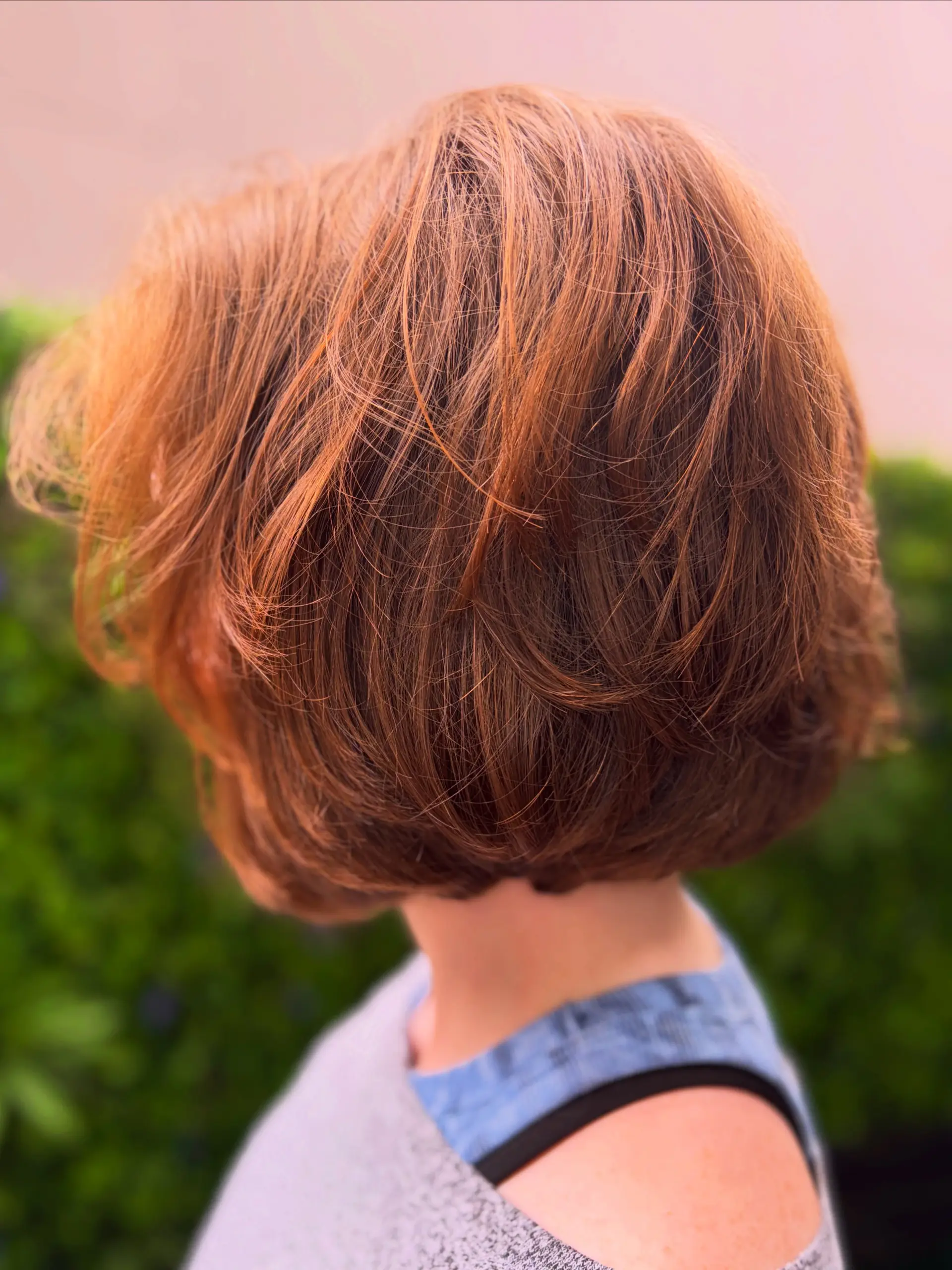 A textured chin-length bob cut styled with soft layers and an airy, voluminous finish in a warm copper tone. 1