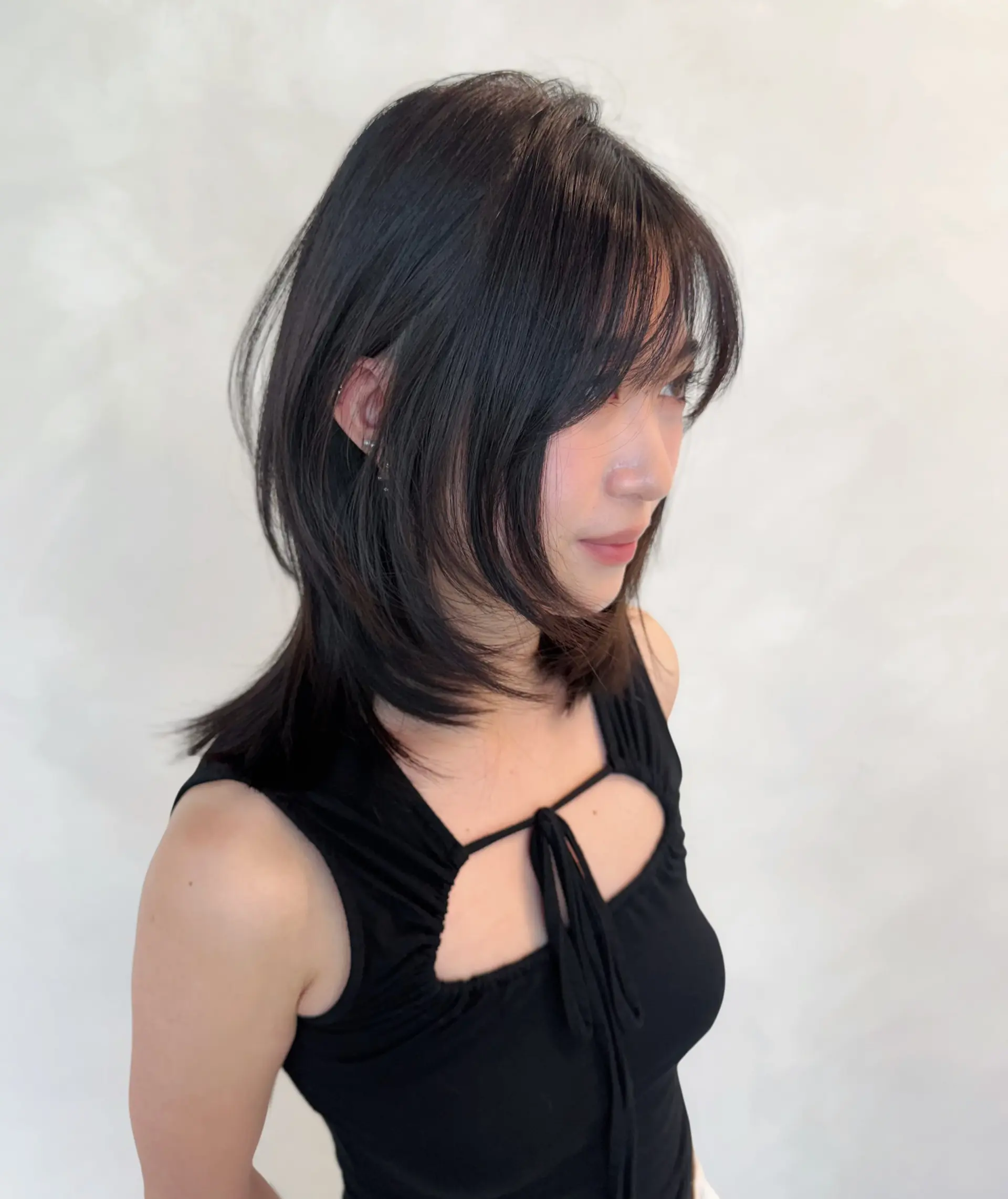 Medium-length layered cut with face-framing layers and soft, wispy see-through bangs. 1