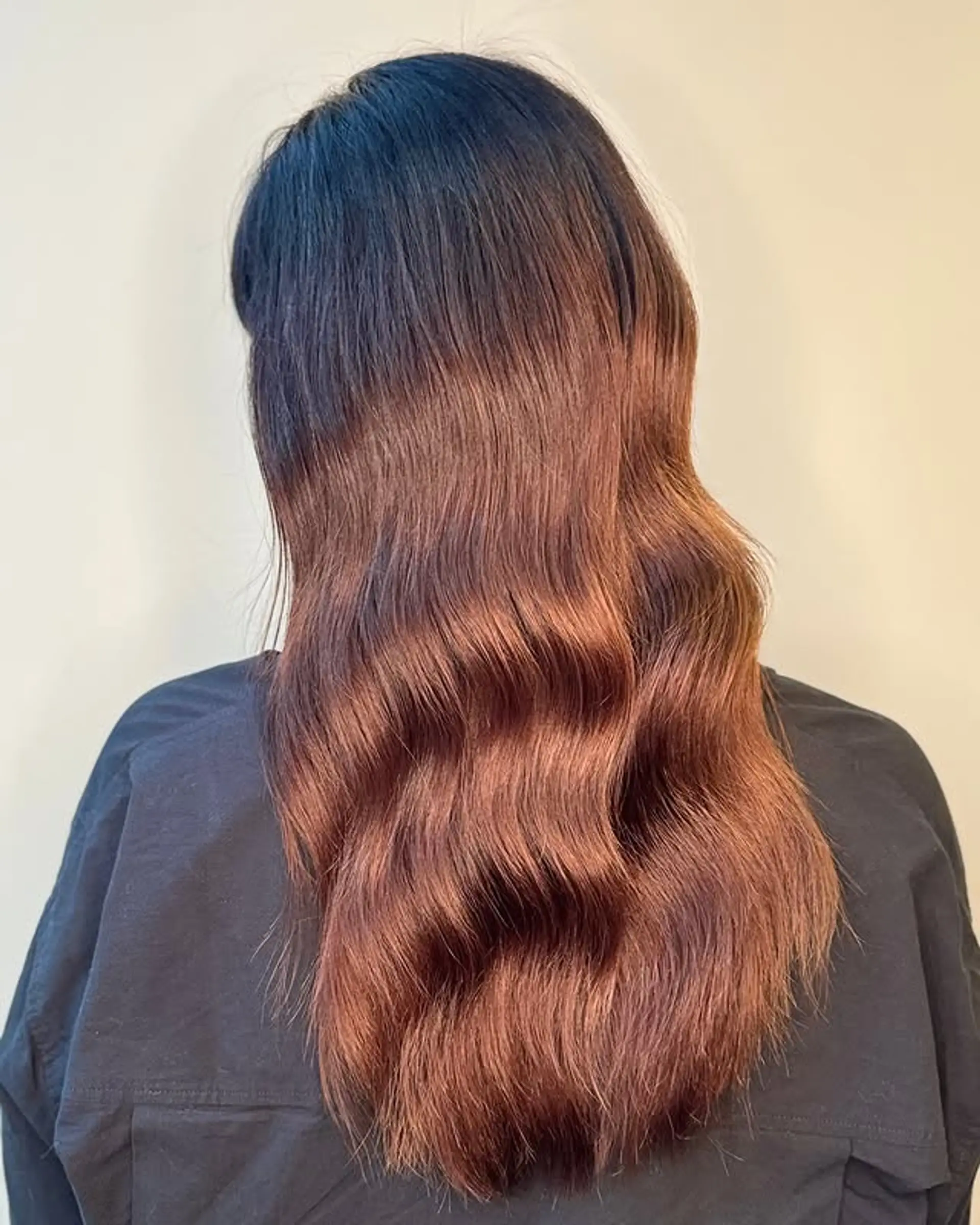 Long wavy hair with a dark root and copper ombre. 1