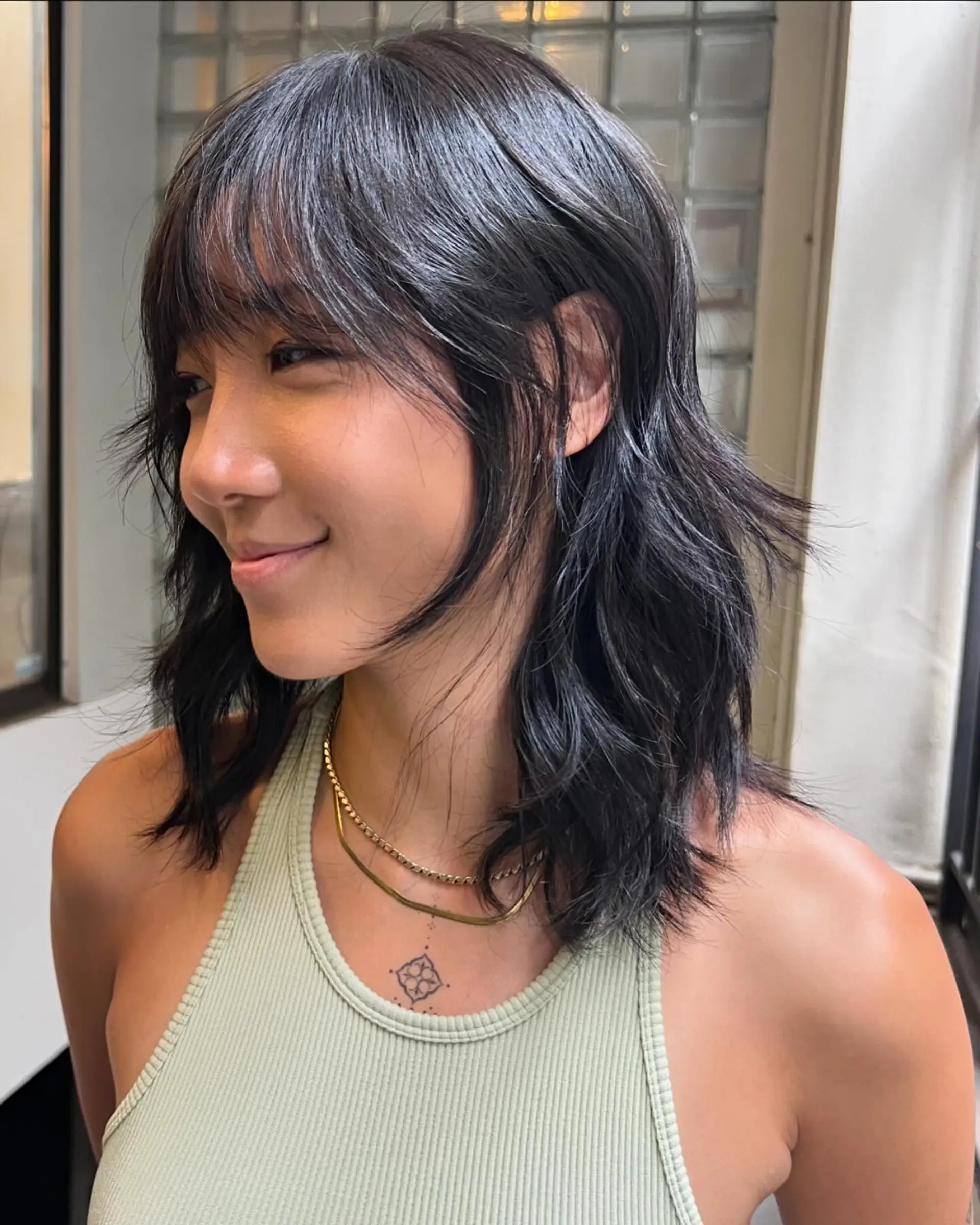 Medium-length wavy hair with soft, loose waves, side-swept bangs, and subtle layers for added texture and natural shine. 1