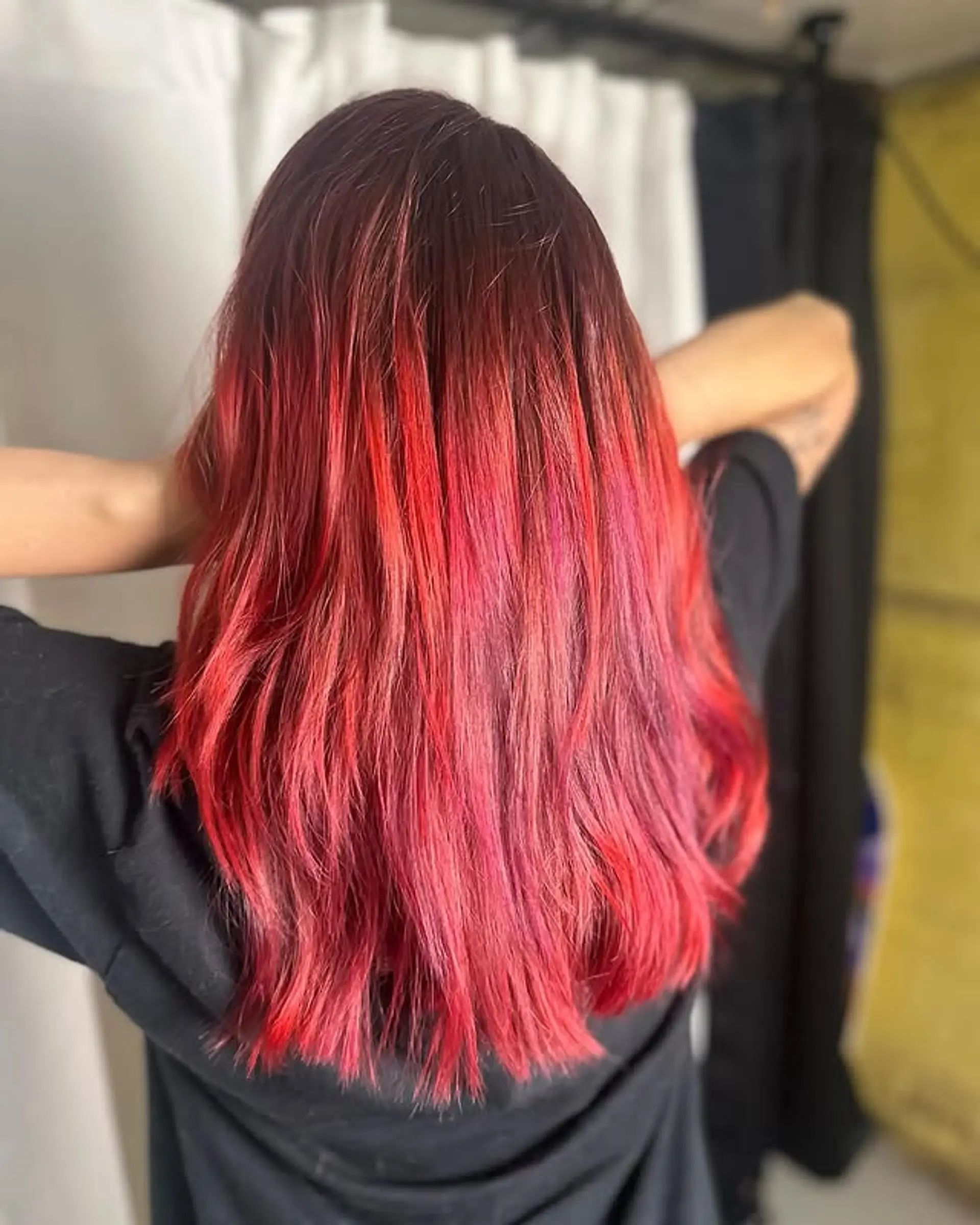 A long, layered hairstyle featuring a dark base color that seamlessly blends into a bright crimson red. 1