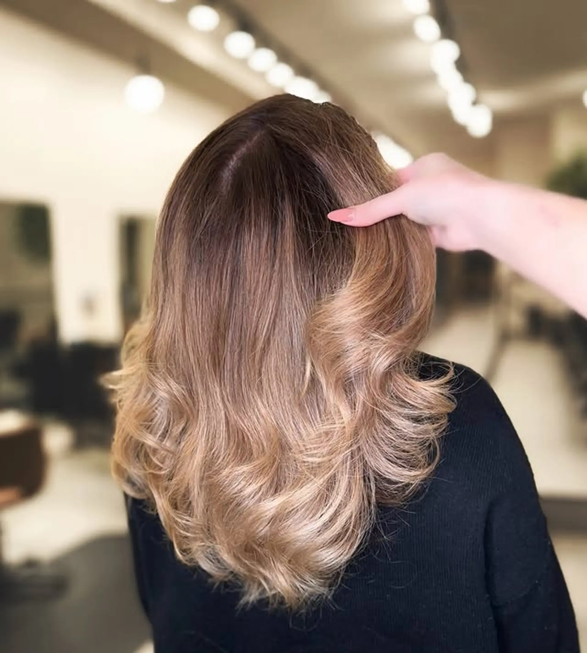 A medium-length wavy hairstyle featuring a seamless ombre balayage, with soft, blended colors and beachy waves. 1