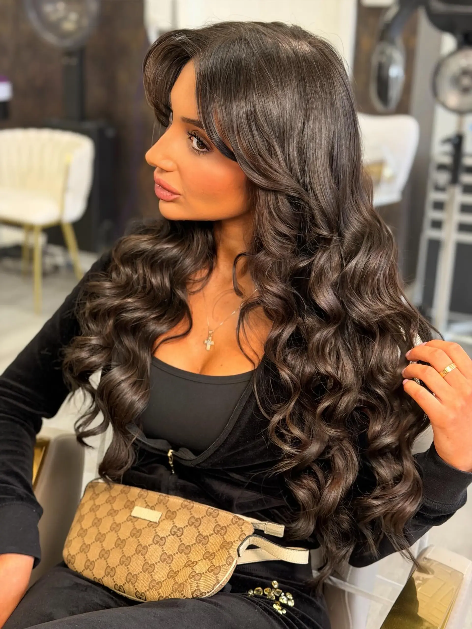 Rich, glossy dark brown hair styled into bouncy, voluminous curls with softly styled bangs. 1