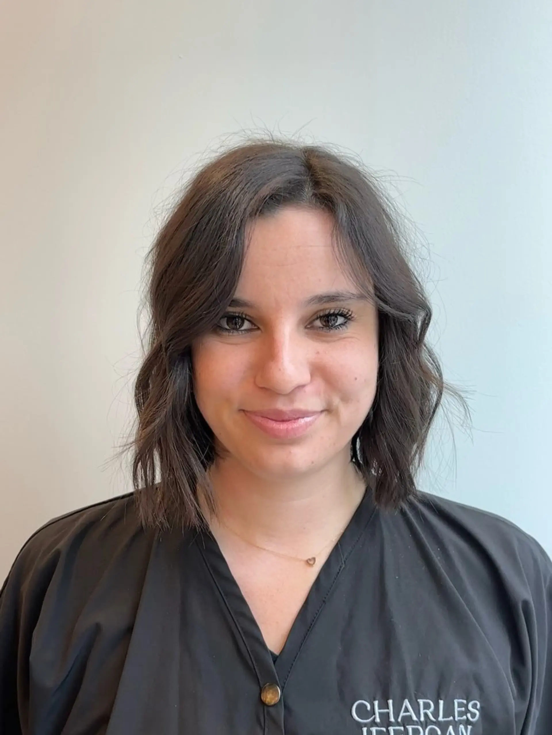 A textured chin-to-collarbone dark brown bob styled with loose, effortless waves and a soft center part. 1