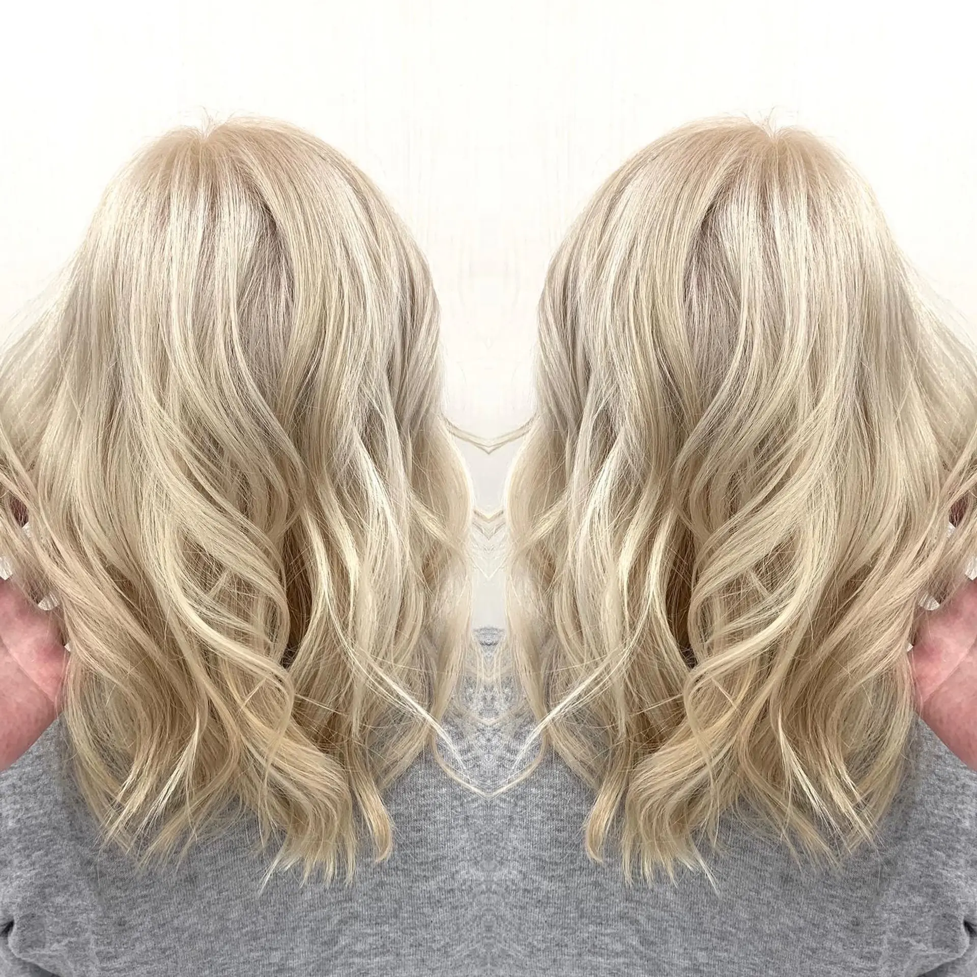 Medium-length vanilla blonde hair styled with soft, textured waves and loose curls. 1