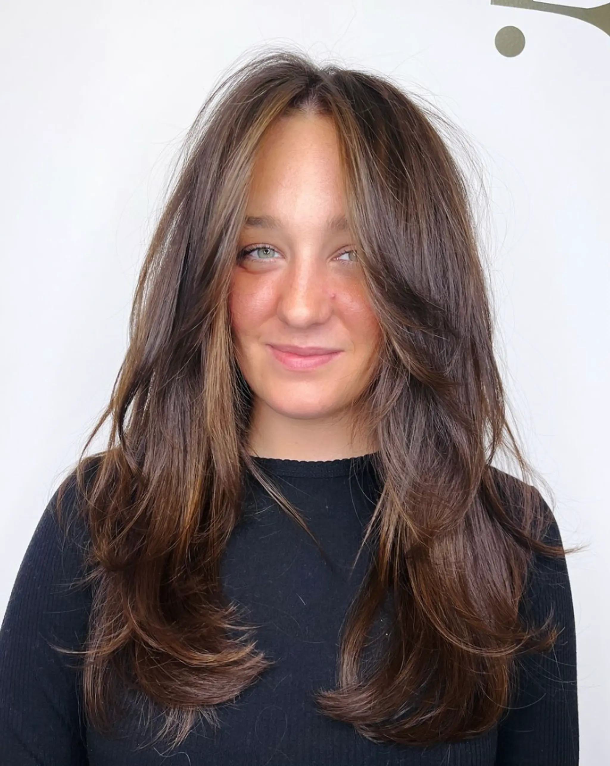 Beautifully layered, long wavy hair with a natural brown base and light brown highlights. The face-framing layers add depth and dimension.

Cut and style by @juliamannino_hair


