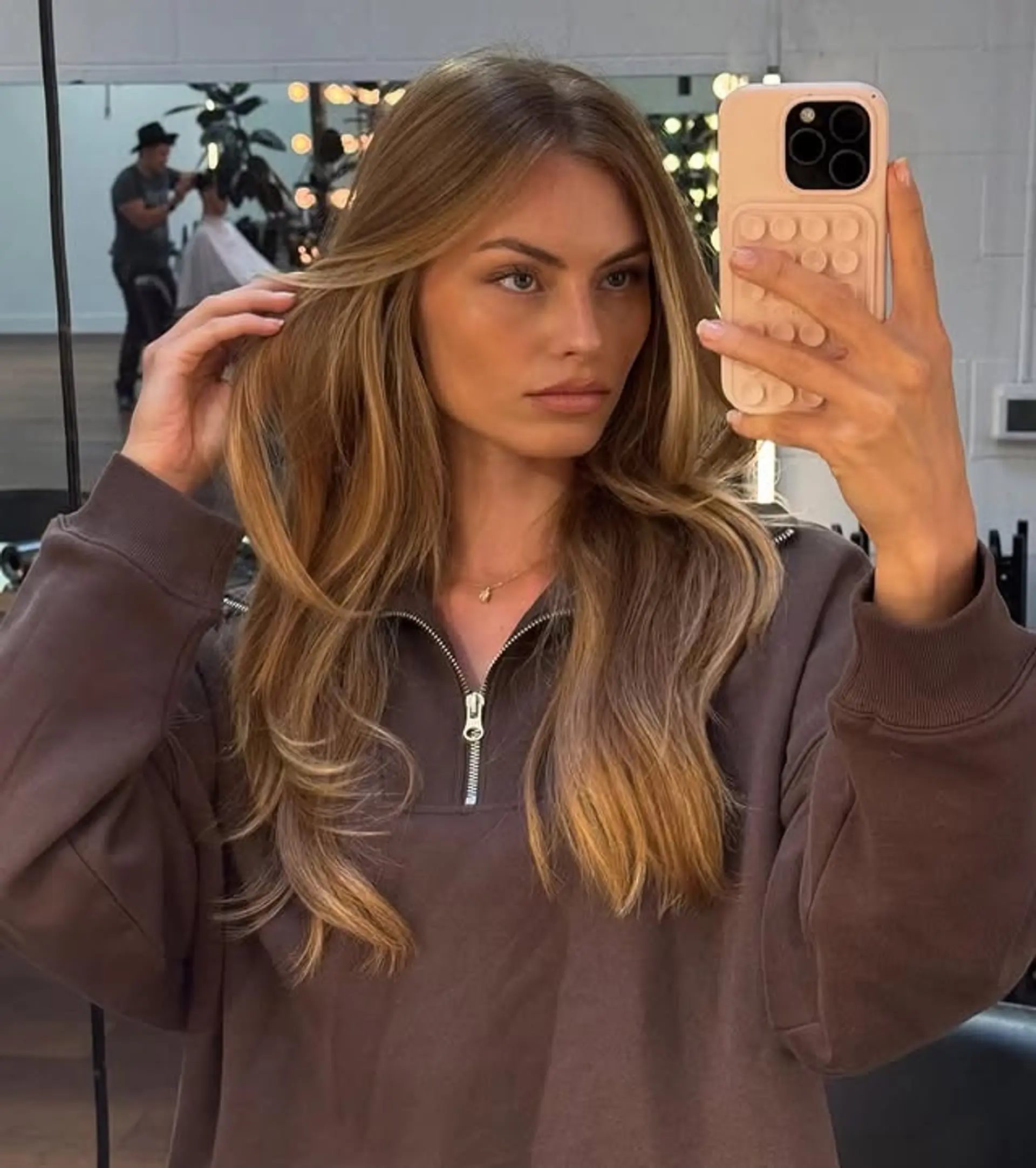 A long, layered hairstyle with balayage blonde highlights and soft beachy waves. 1