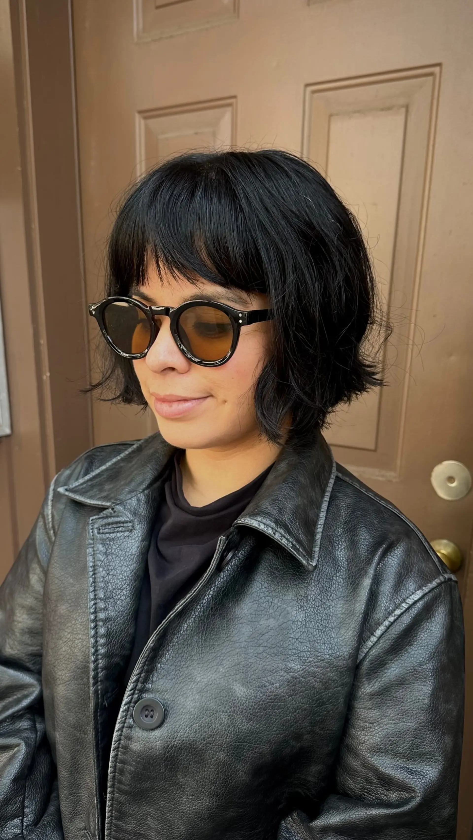 A jaw-length mini bob featuring tousled, textured ends and classic full bangs. 1