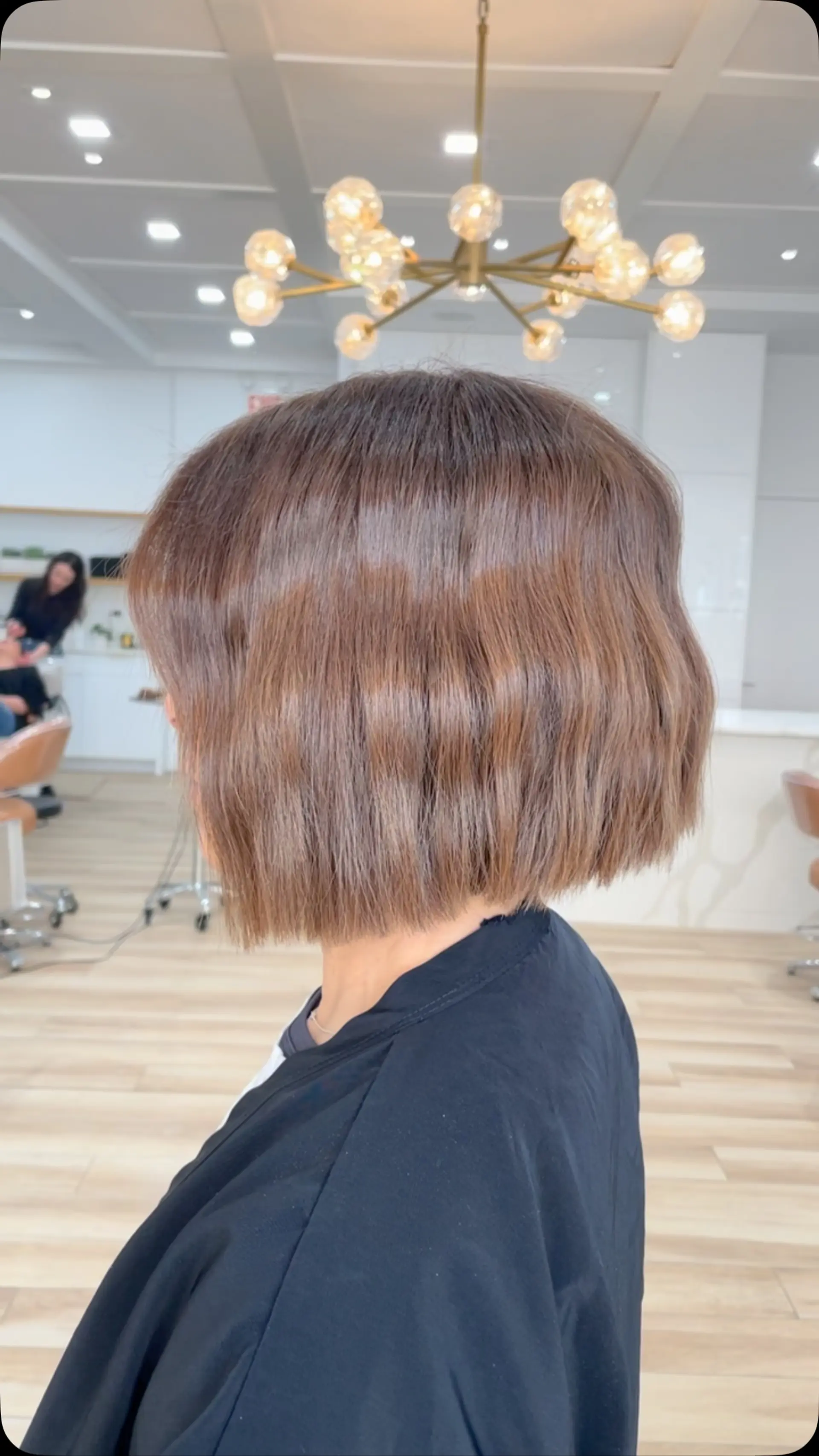 A sleek, chin-length blunt bob styled with soft, textured bends in a rich chocolate brown hue. 1