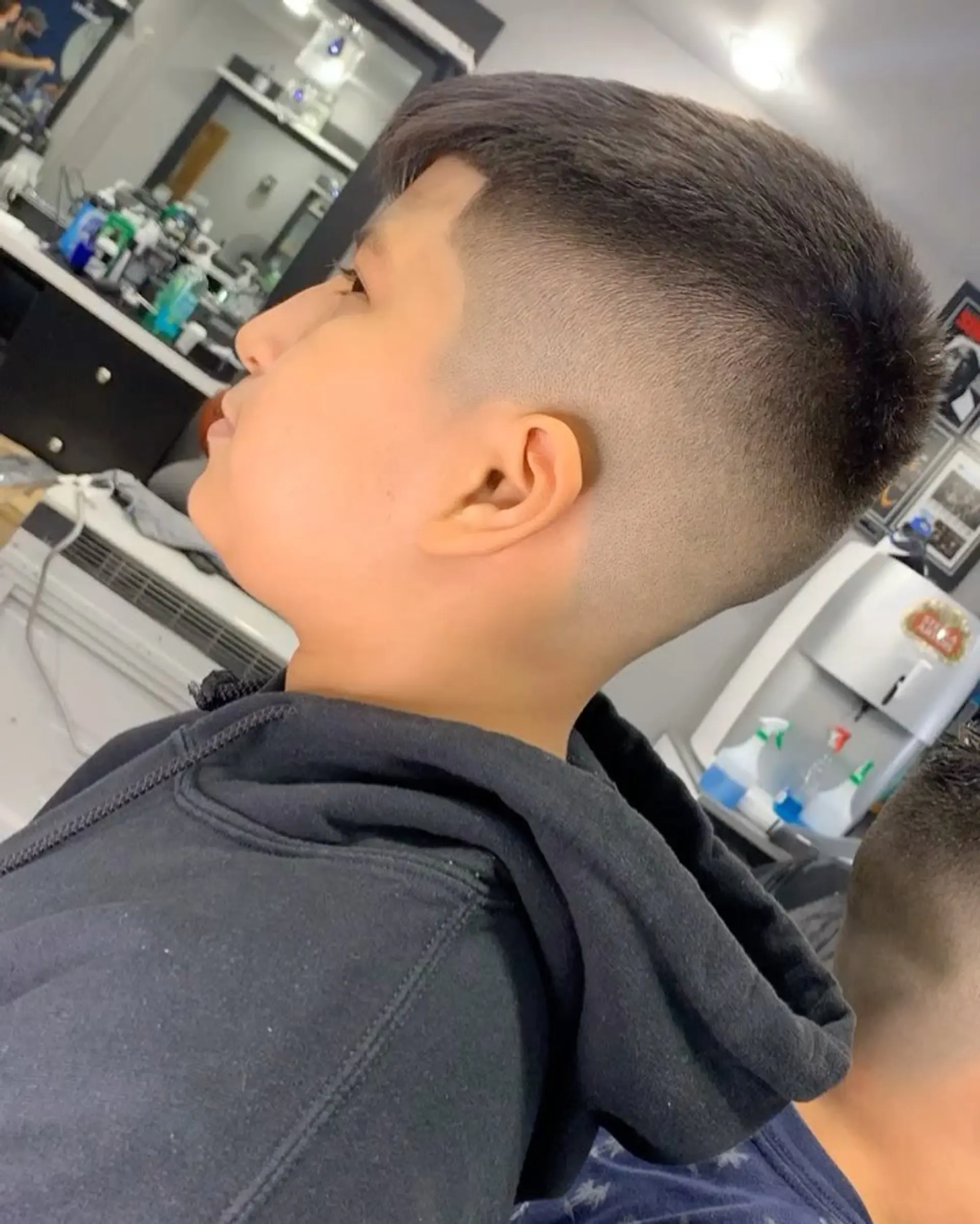A clean mid skin fade with a textured short crop and crisp hairline detailing. 1