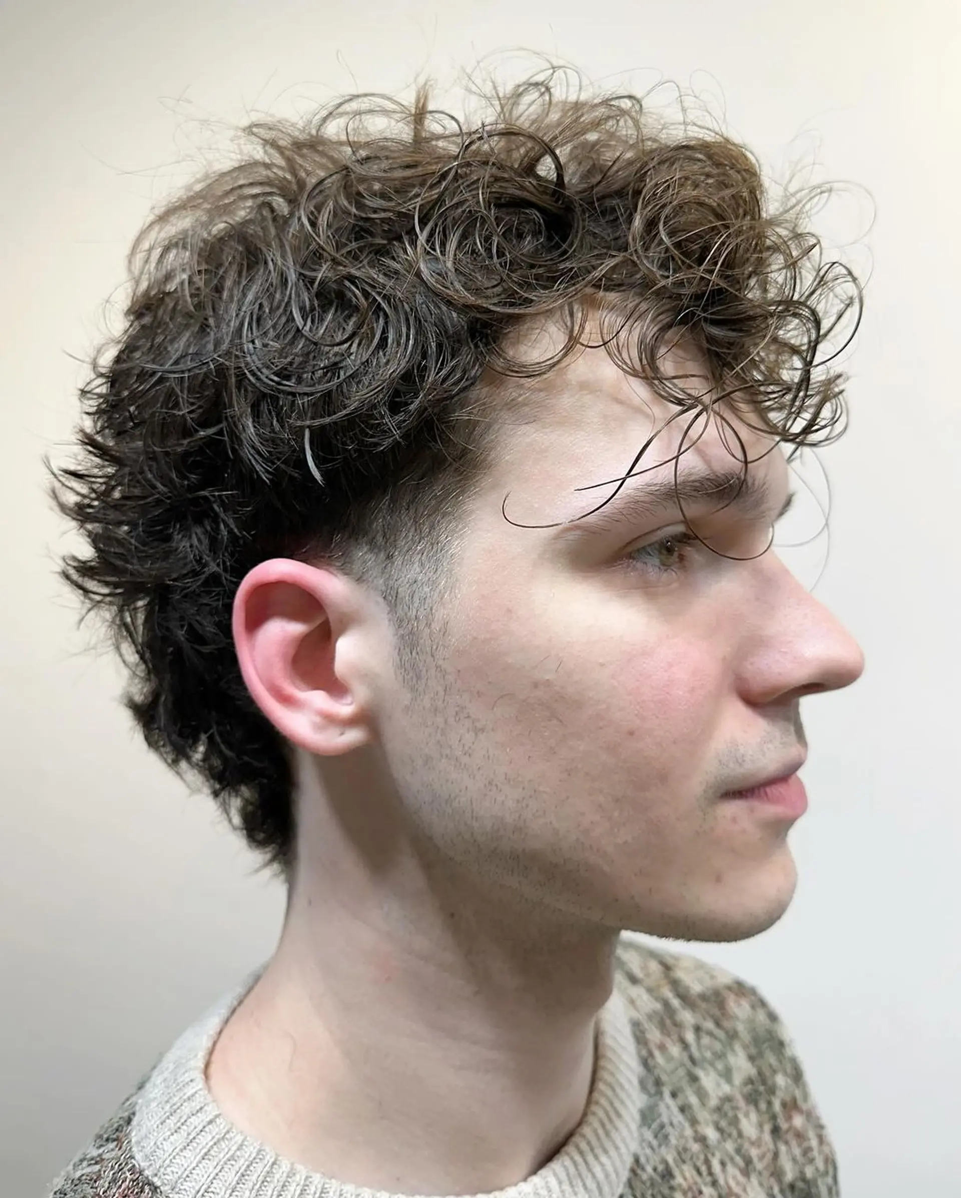 Dark brown curly hairstyle with short length, featuring a curly fringe, layered sides, and a tapered back for natural volume. 1