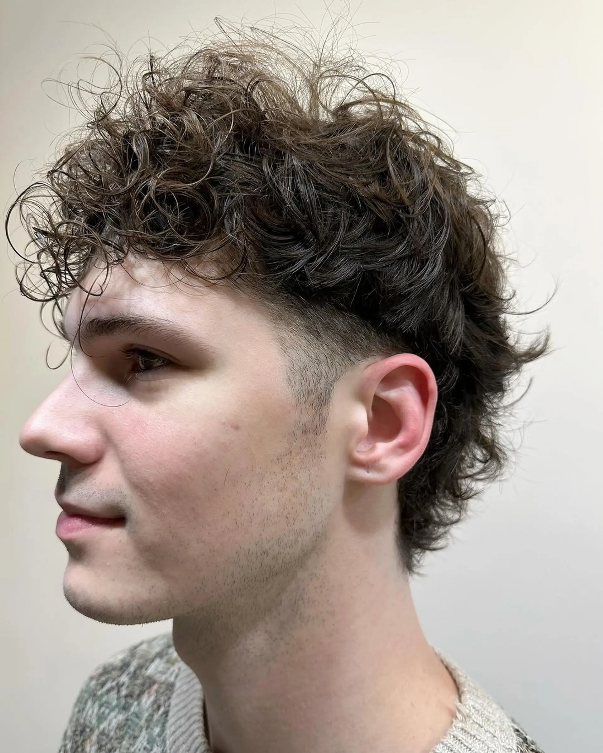 Dark brown curly hairstyle with short length, featuring a curly fringe, layered sides, and a tapered back for natural volume. 2