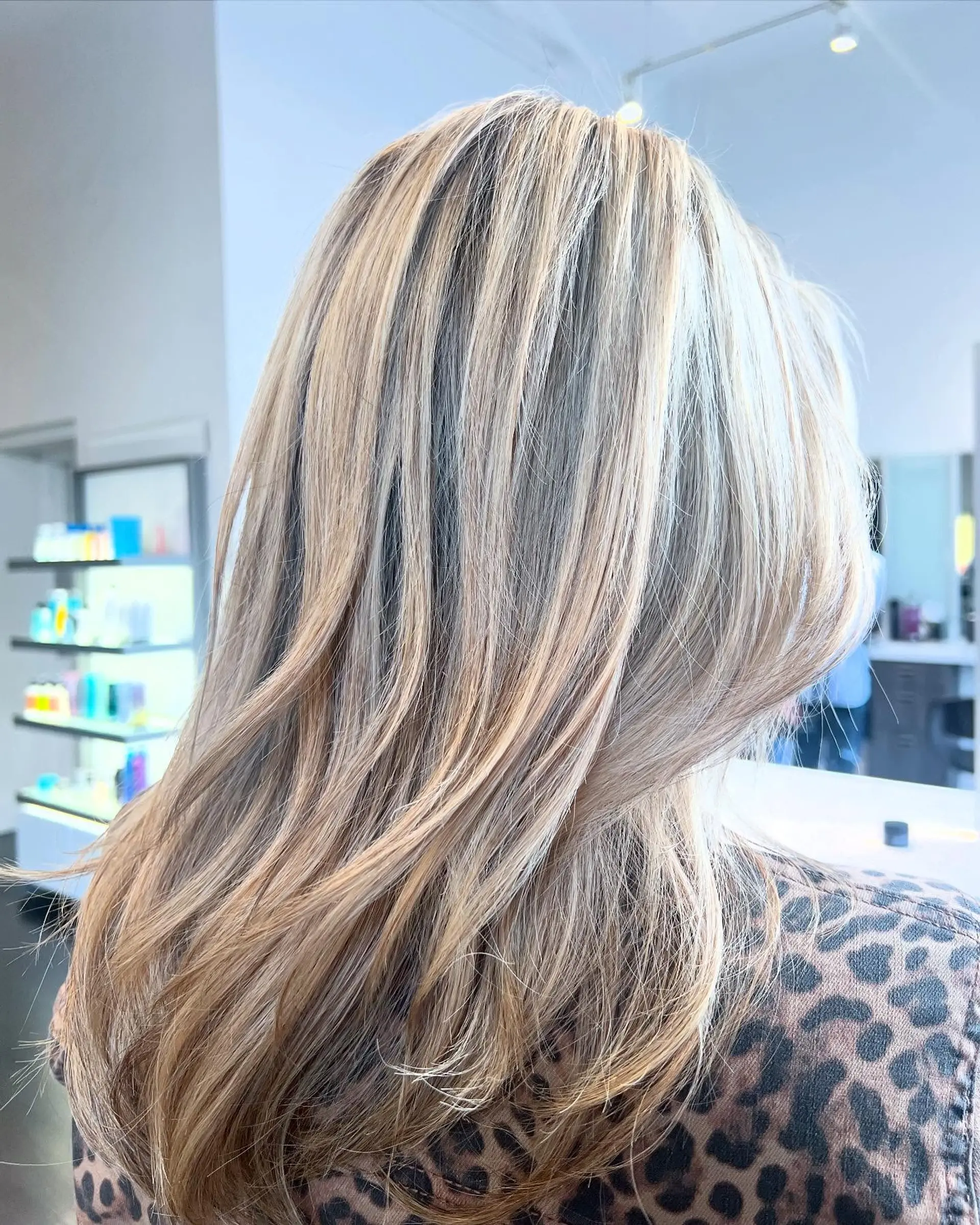 A sleek, layered dimensional blonde blowout with soft movement at the ends. 1