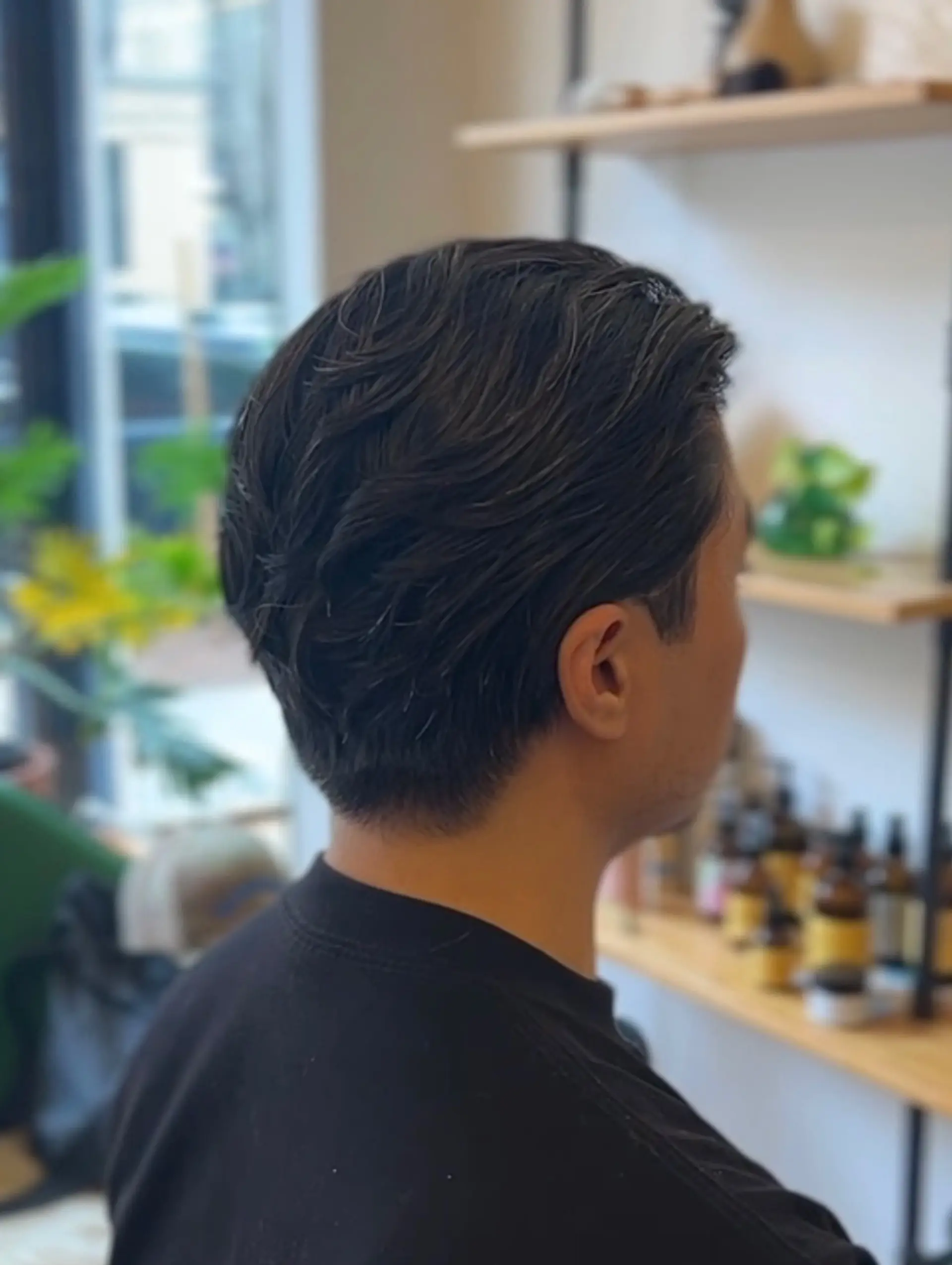 A textured short haircut with soft, swept-back waves on top and clean, neatly tapered sides and neckline. 1