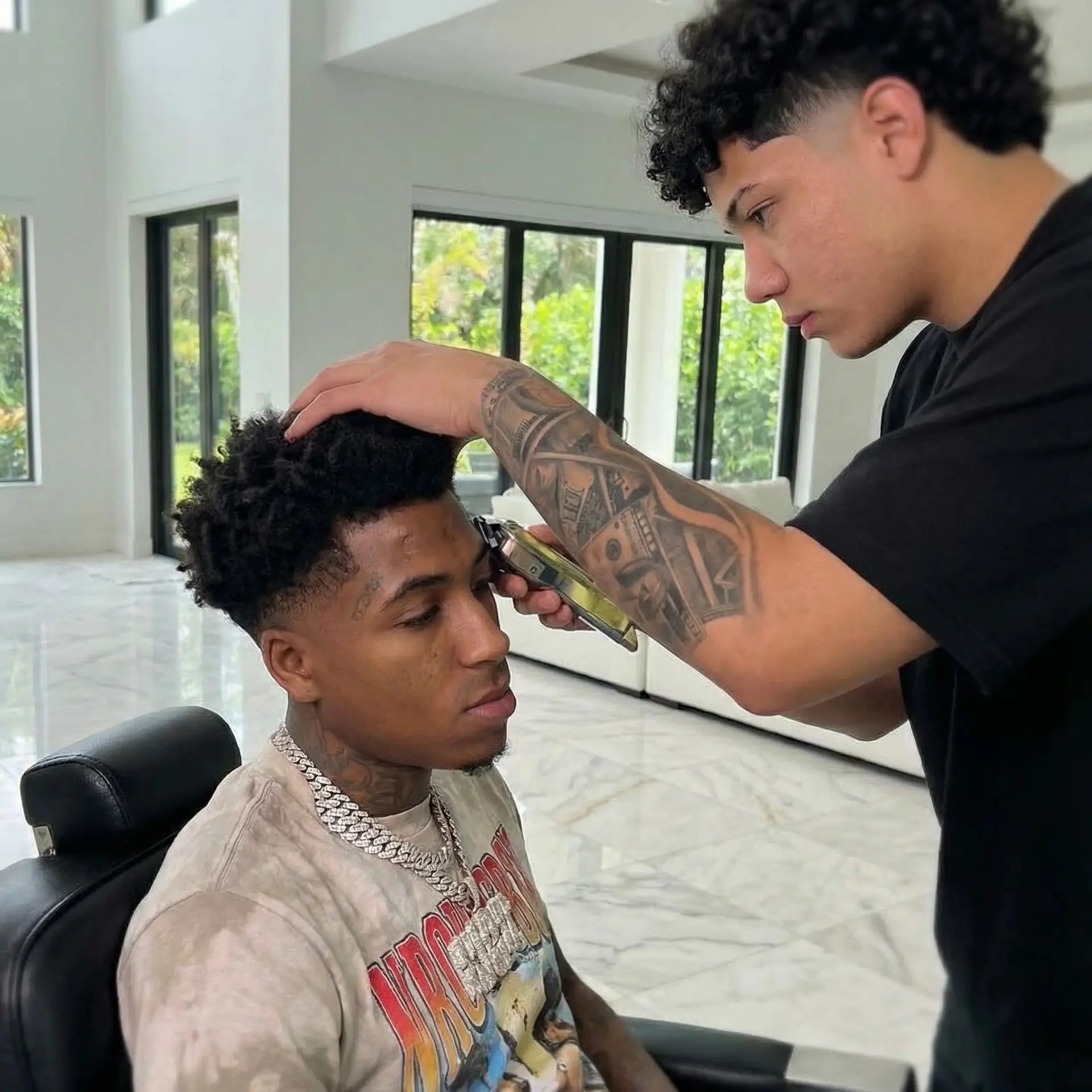 A sharp men's taper fade with natural textured curls on top and a crisp edge up along the hairline. 1