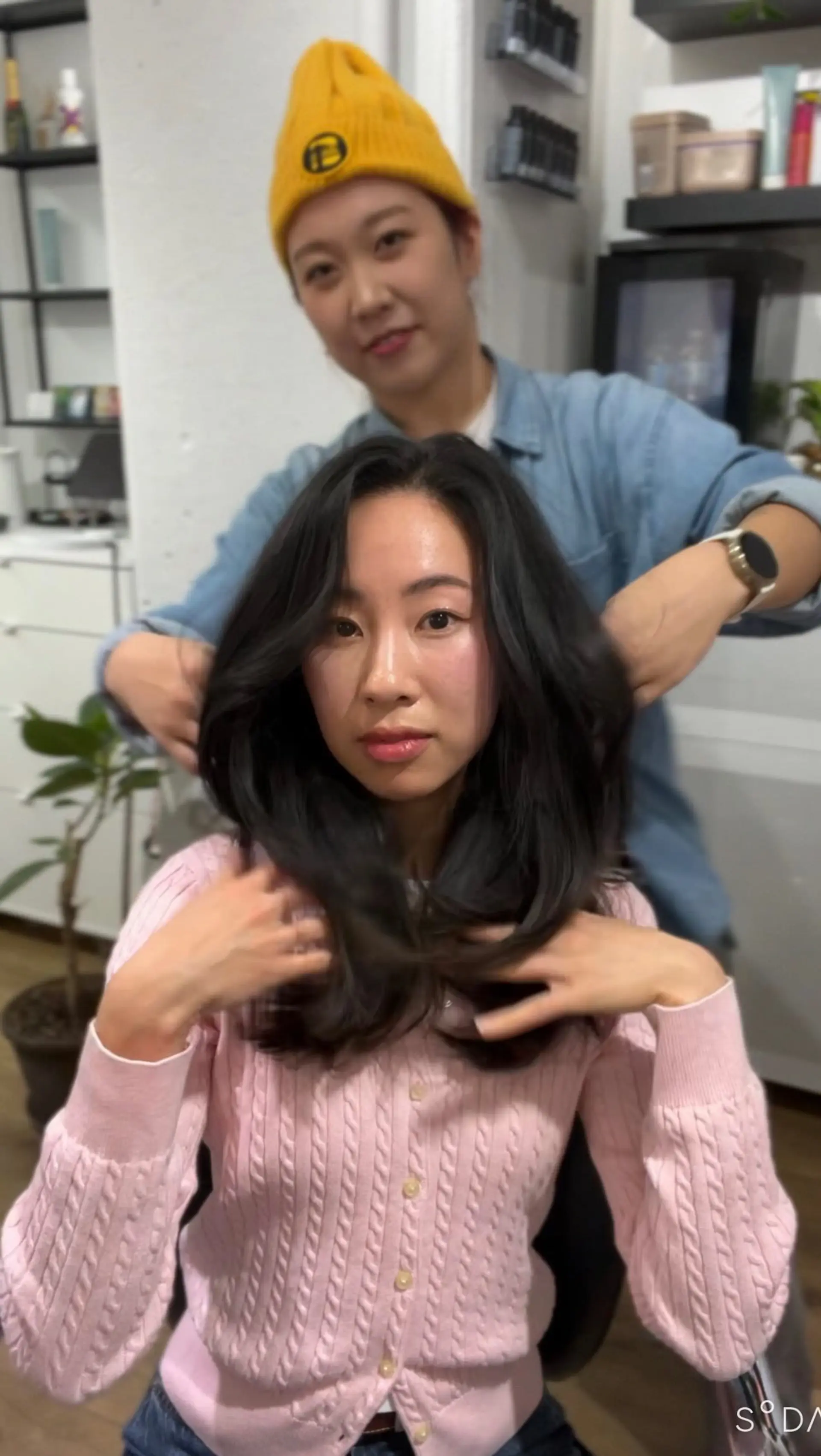 Medium-length dark hair styled with bouncy, face-framing layers and a voluminous blowout. 1