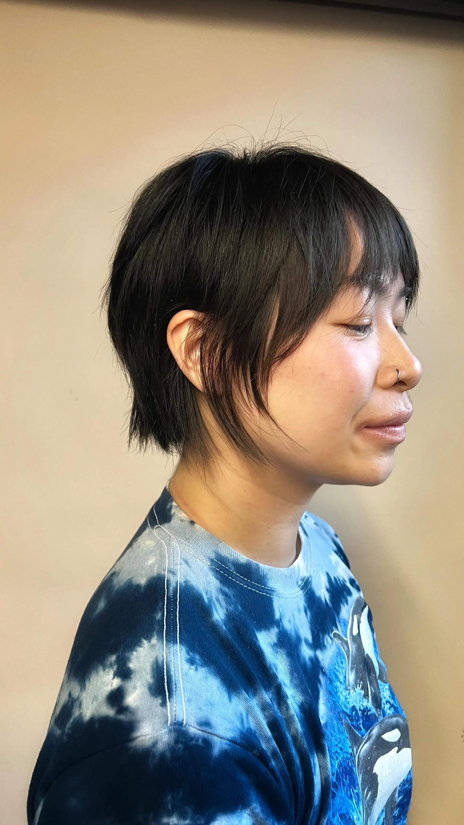 A textured razor-cut bixie with wispy piecey bangs, soft face-framing strands, and tapered nape layering. 1