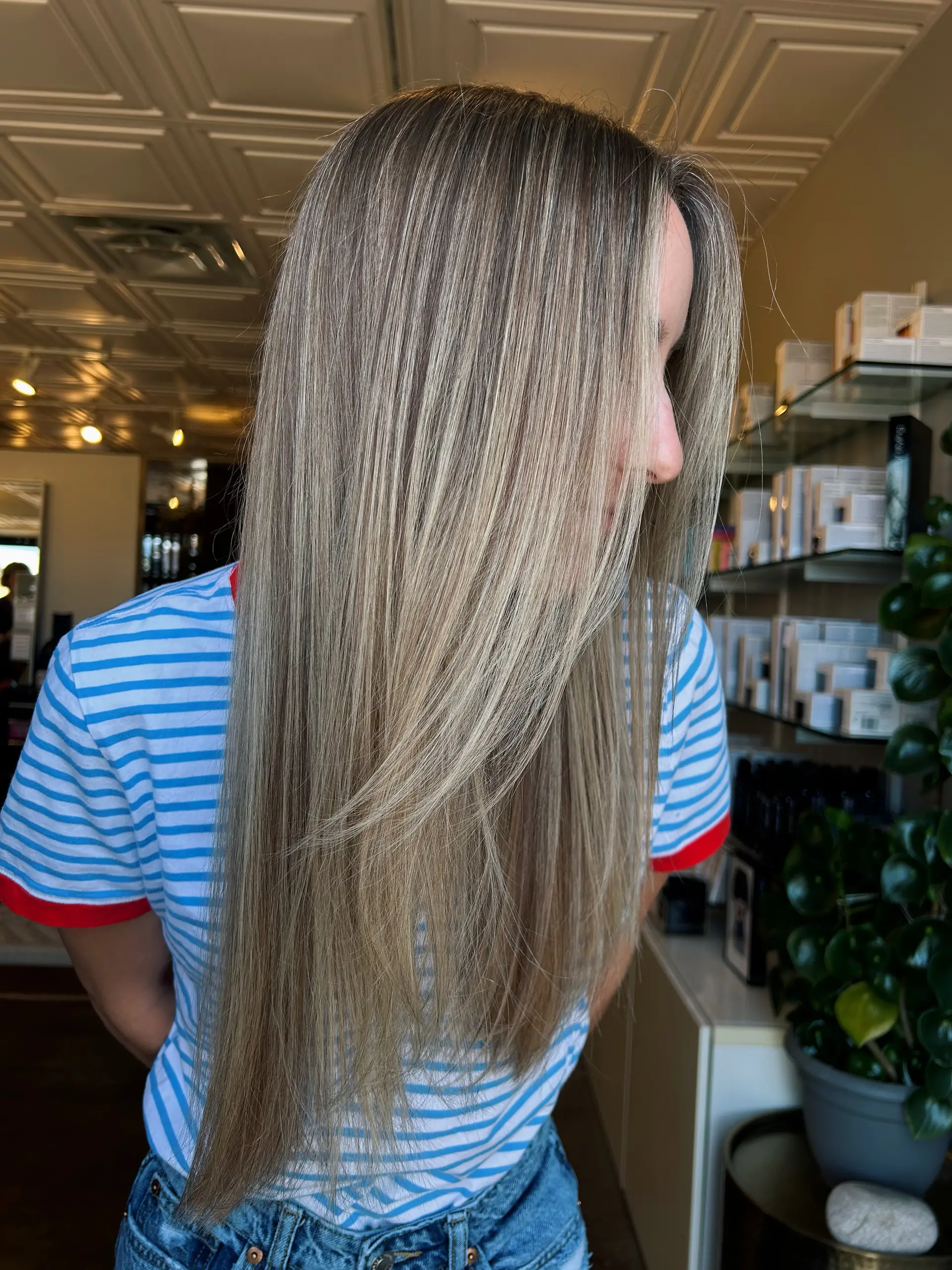 Long, sleek straight hair featuring a blend of bright blonde highlights and subtle lowlights for a natural lived-in dimensional look. 1