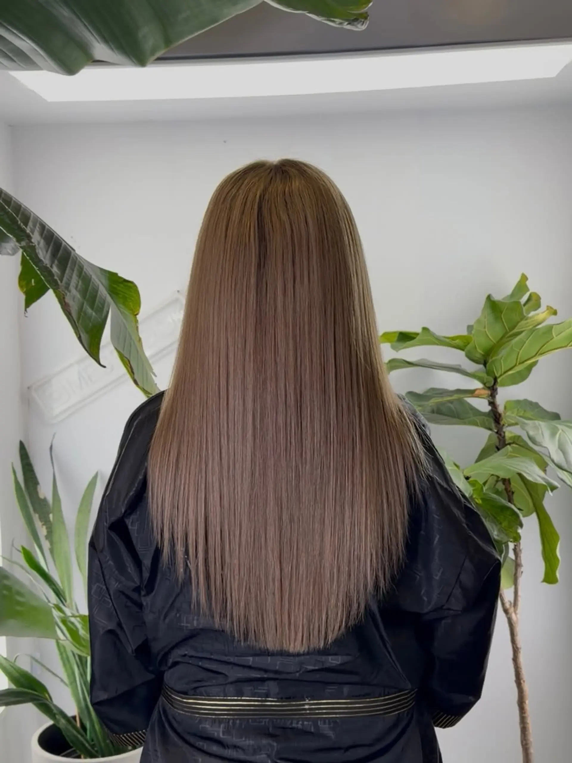 Long, perfectly straight hair styled into a V-cut at the ends, creating a smooth and streamlined silhouette. 1