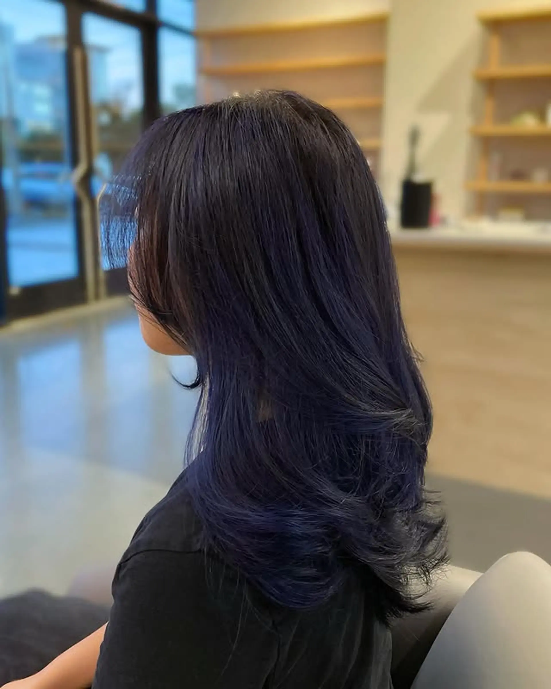 Long layered haircut with face-framing bangs and a stunning midnight blue color. 1