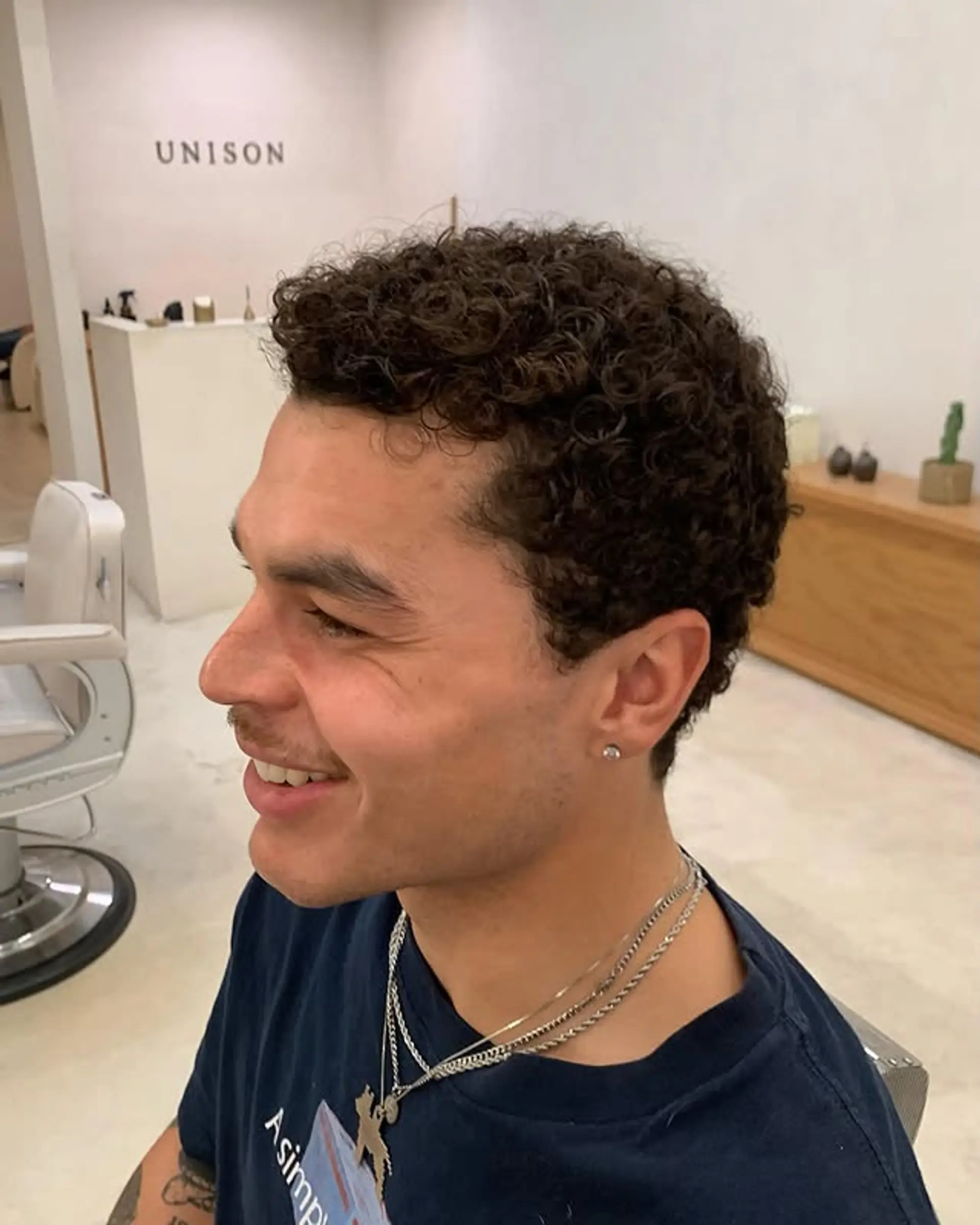 Short, defined curly hair with a modern crop. 1