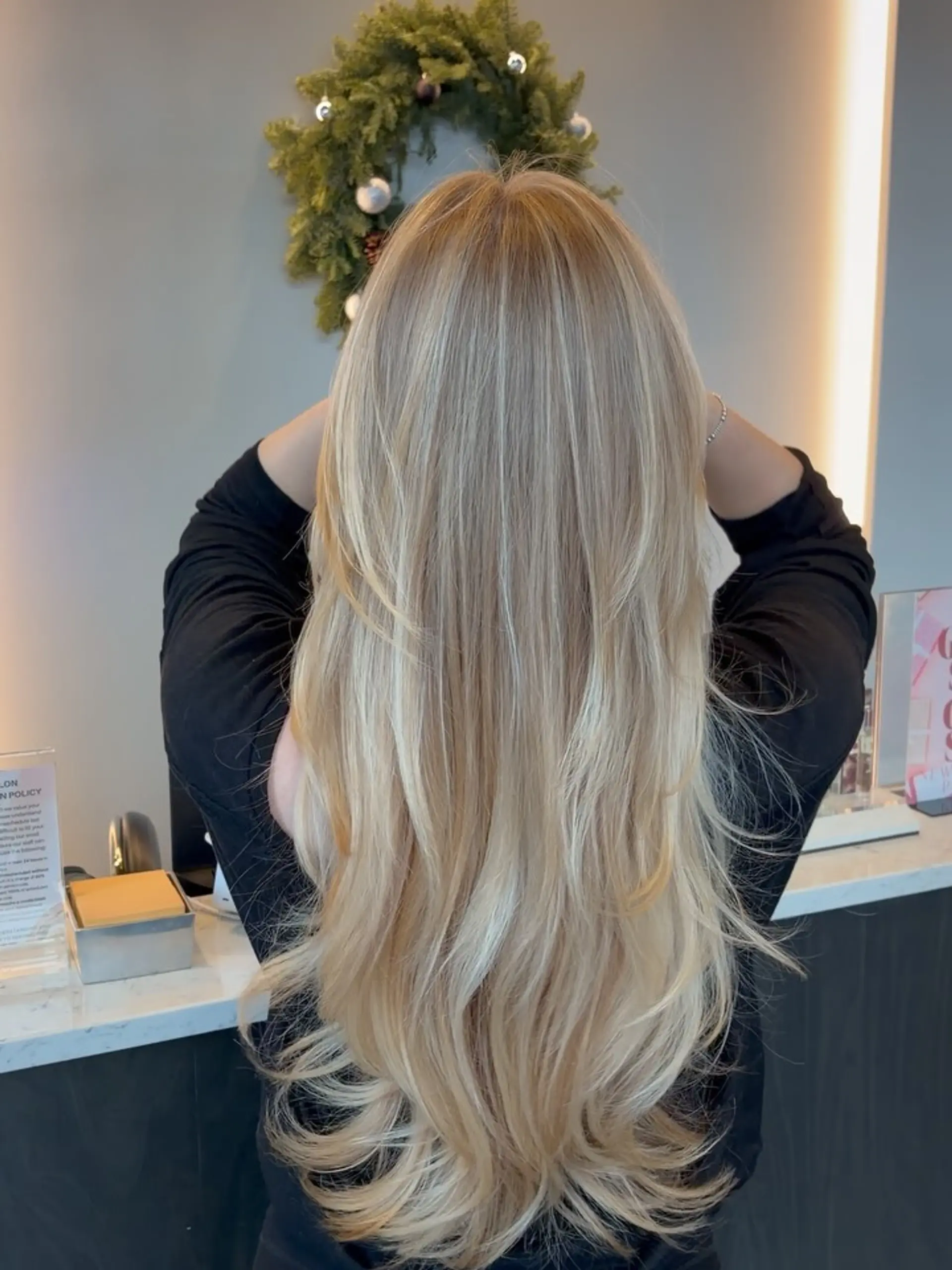 Long, dimensional blonde balayage styled in flowing layers with soft curved ends. 1