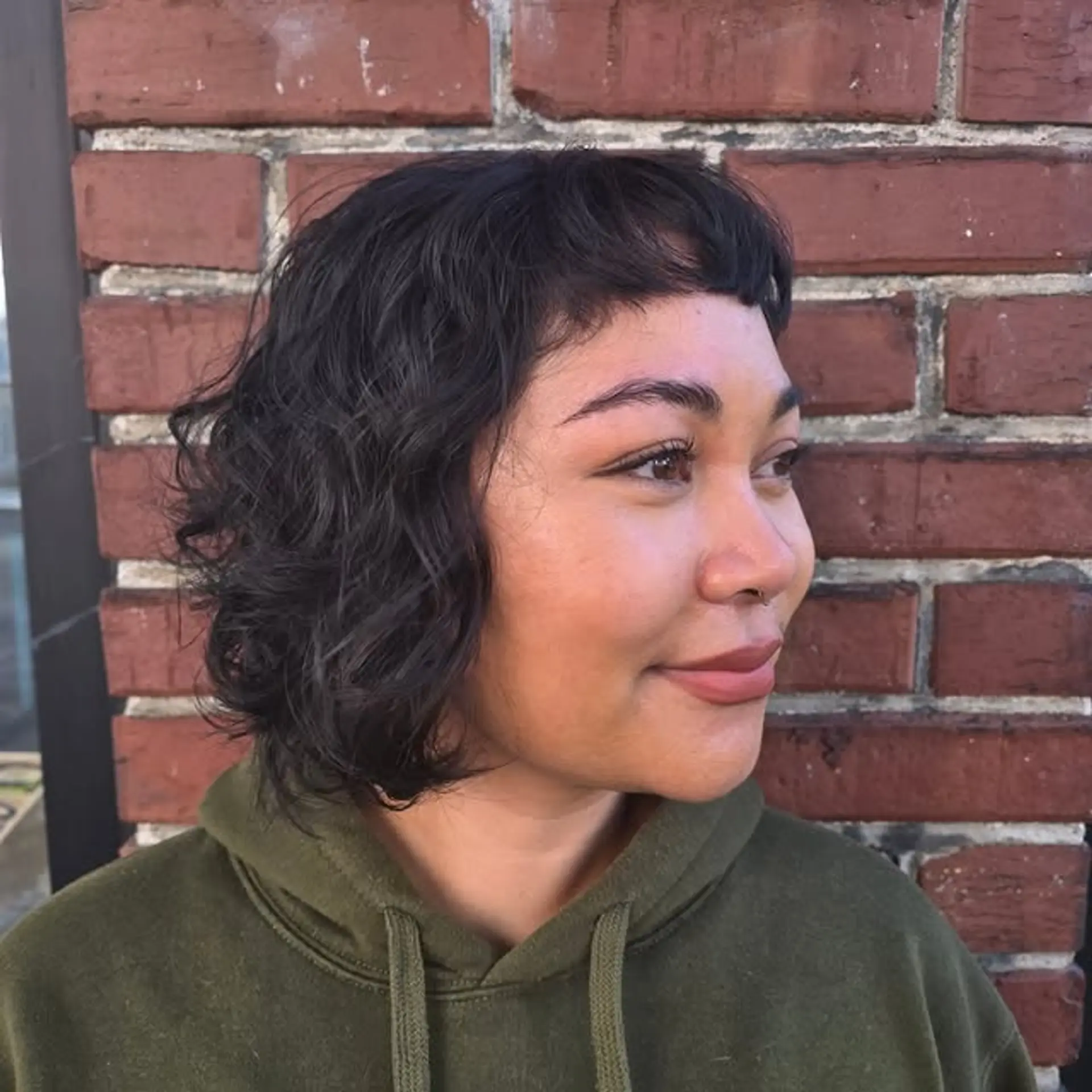 A chic and trendy medium-length wavy bob with blunt baby bangs. 1