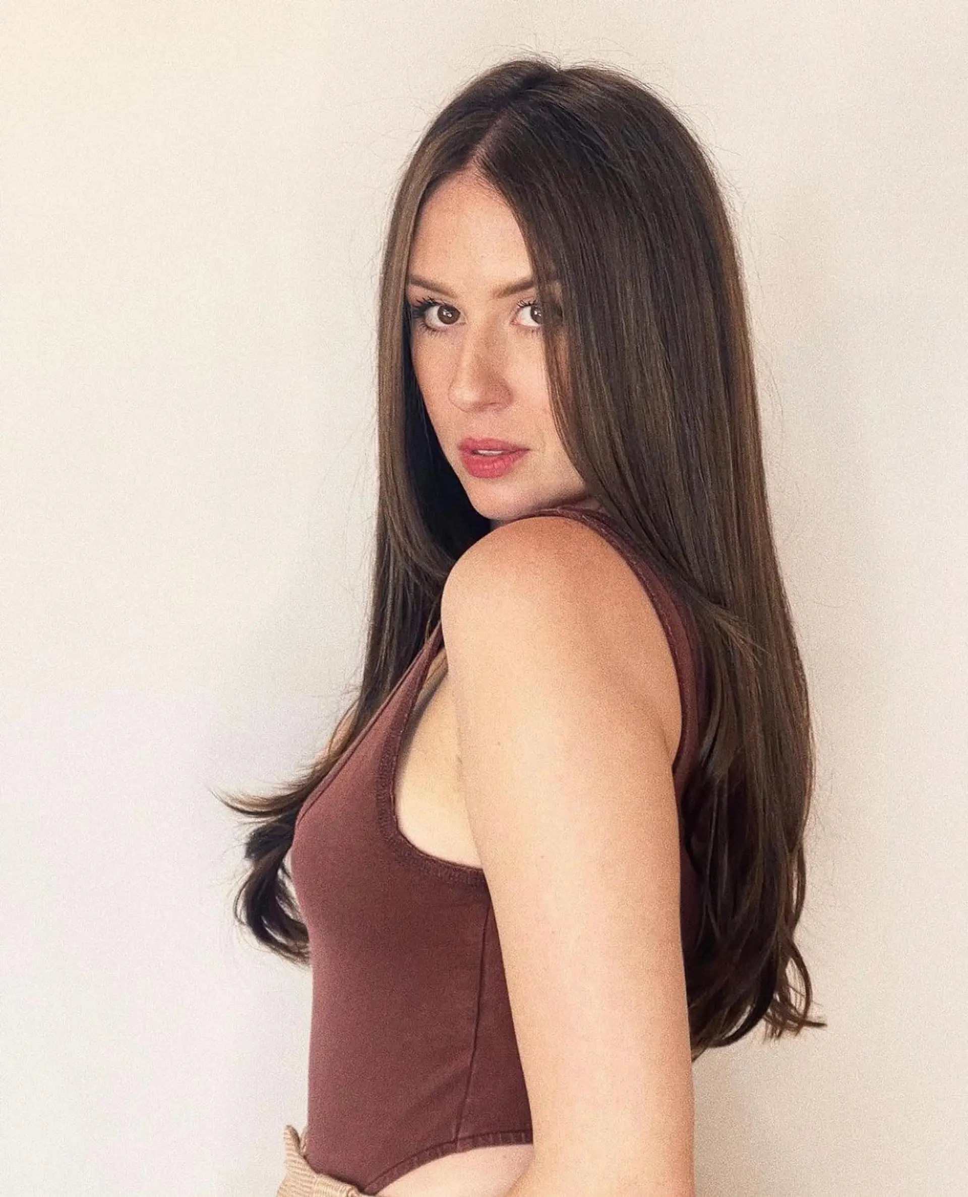 Long, glossy rich brunette hair styled smooth with a center part and subtle flips at the ends. 1