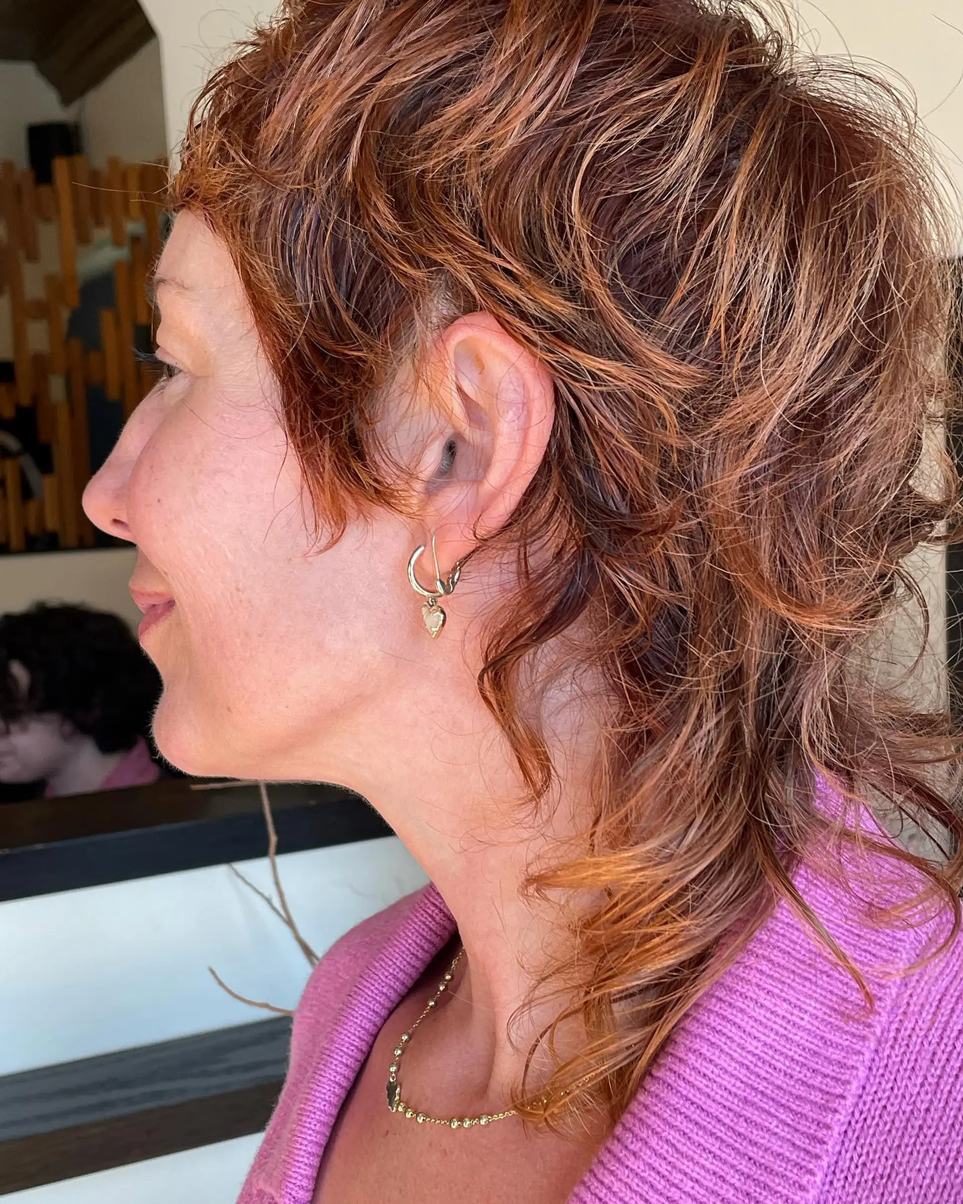 This is a modern take on the classic mullet, featuring a textured, layered cut with a copper color. 1